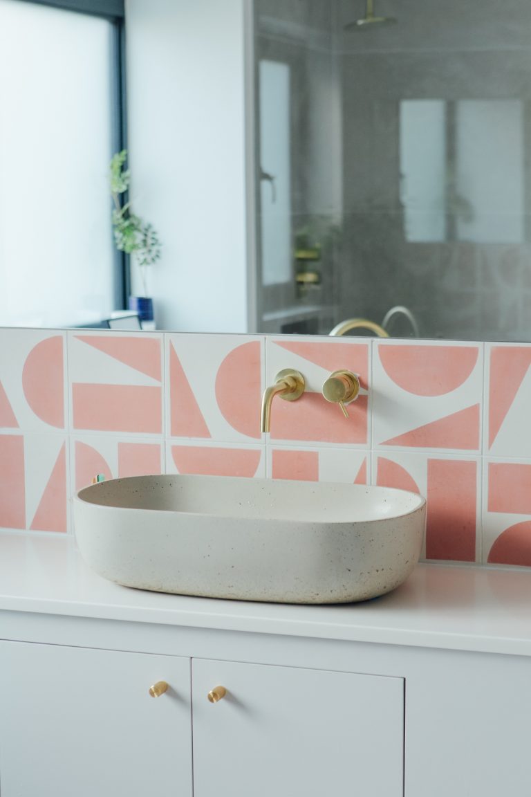bathroom sink with pink splashback tiles
