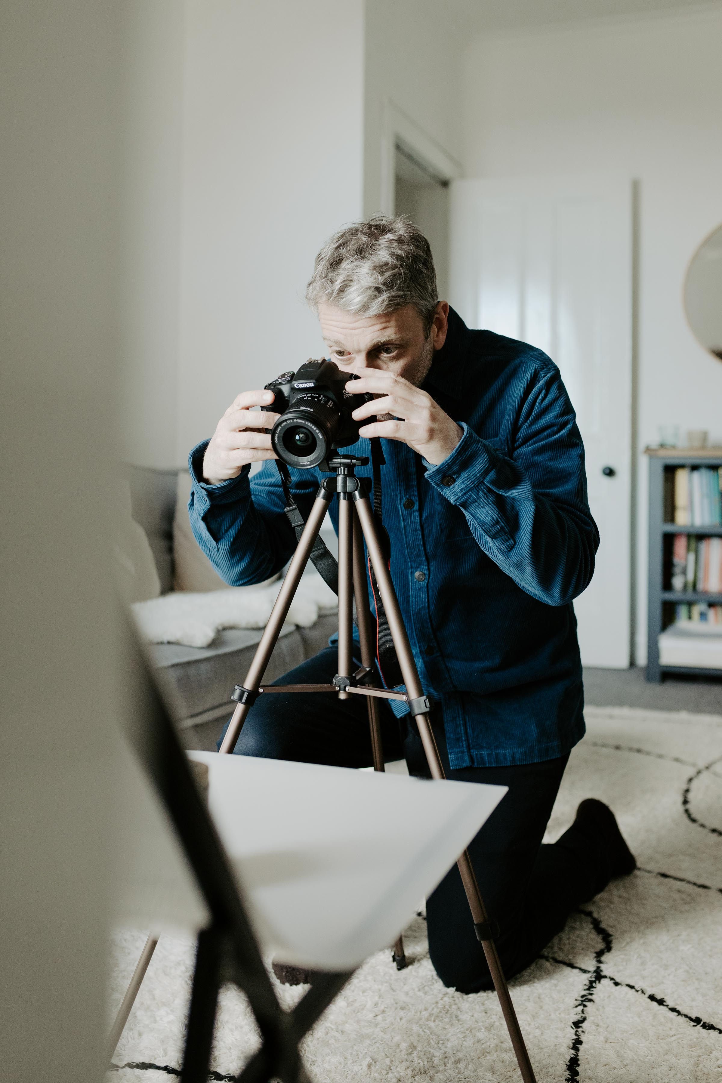 Man with camera taking photos in a living room