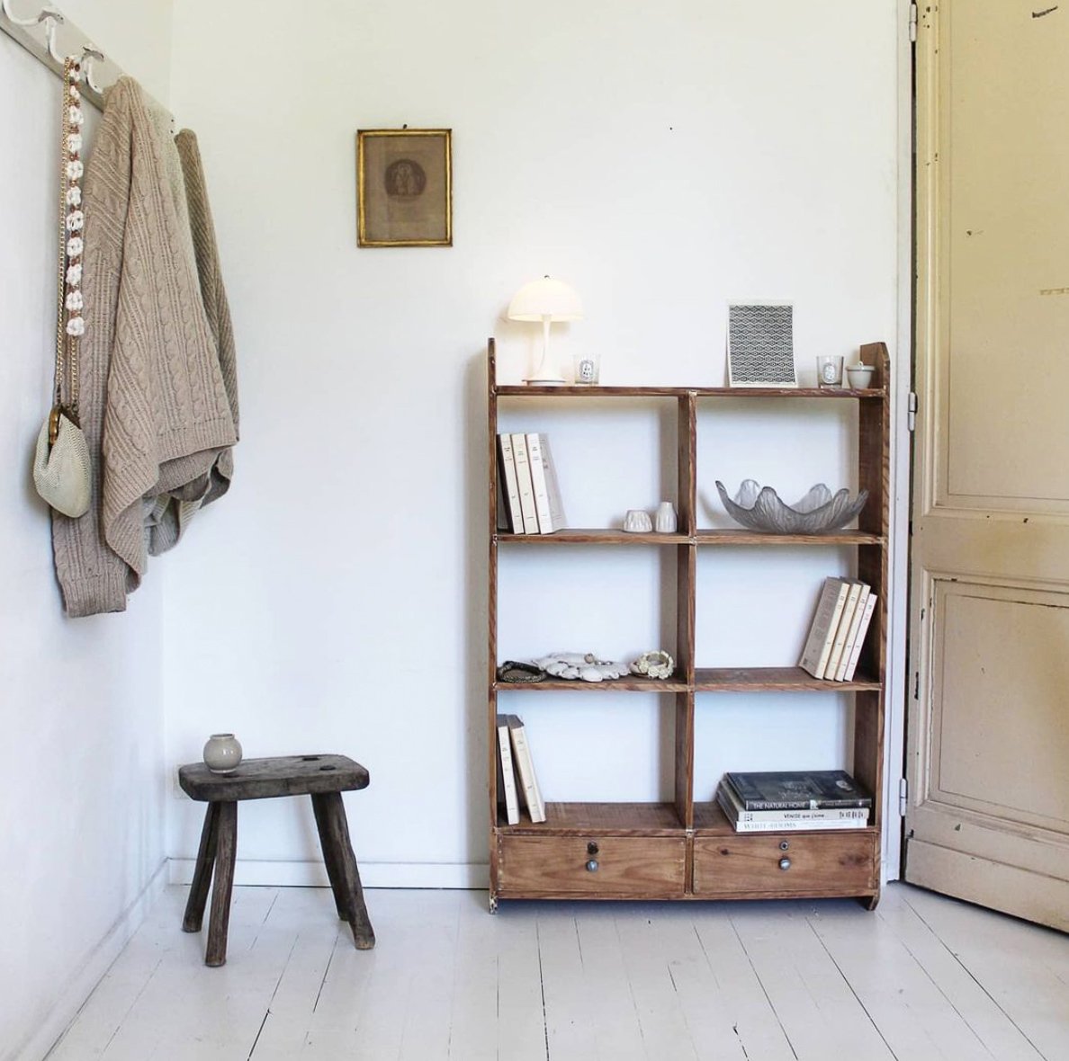 White interior with wooden vintage shelving unit displaying vintage items