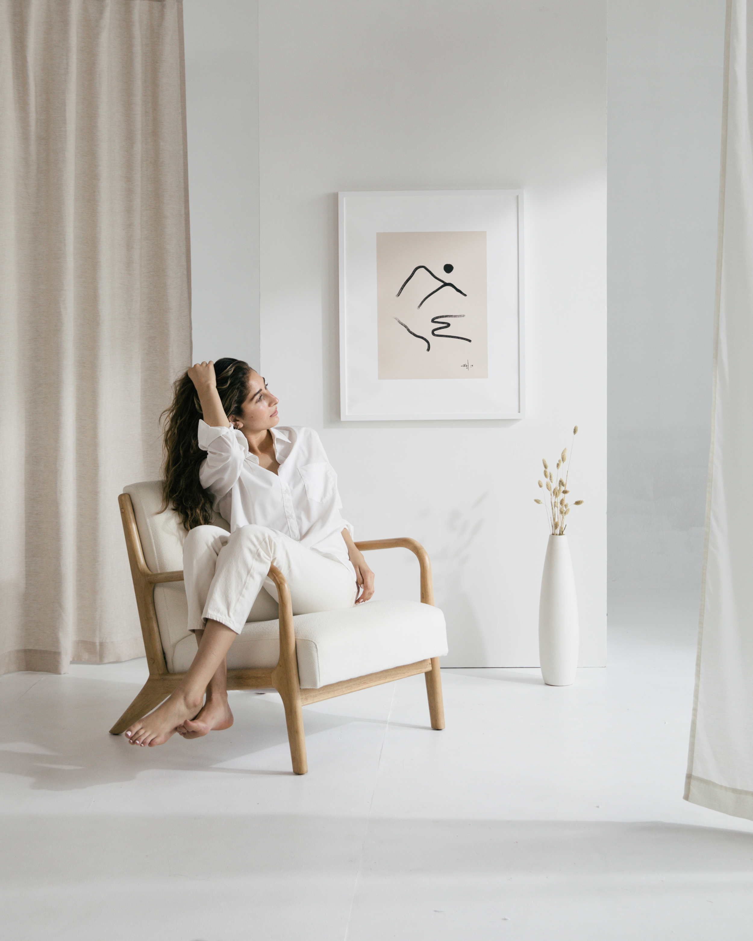 Woman relaxing on chair with minimal artwork on wall