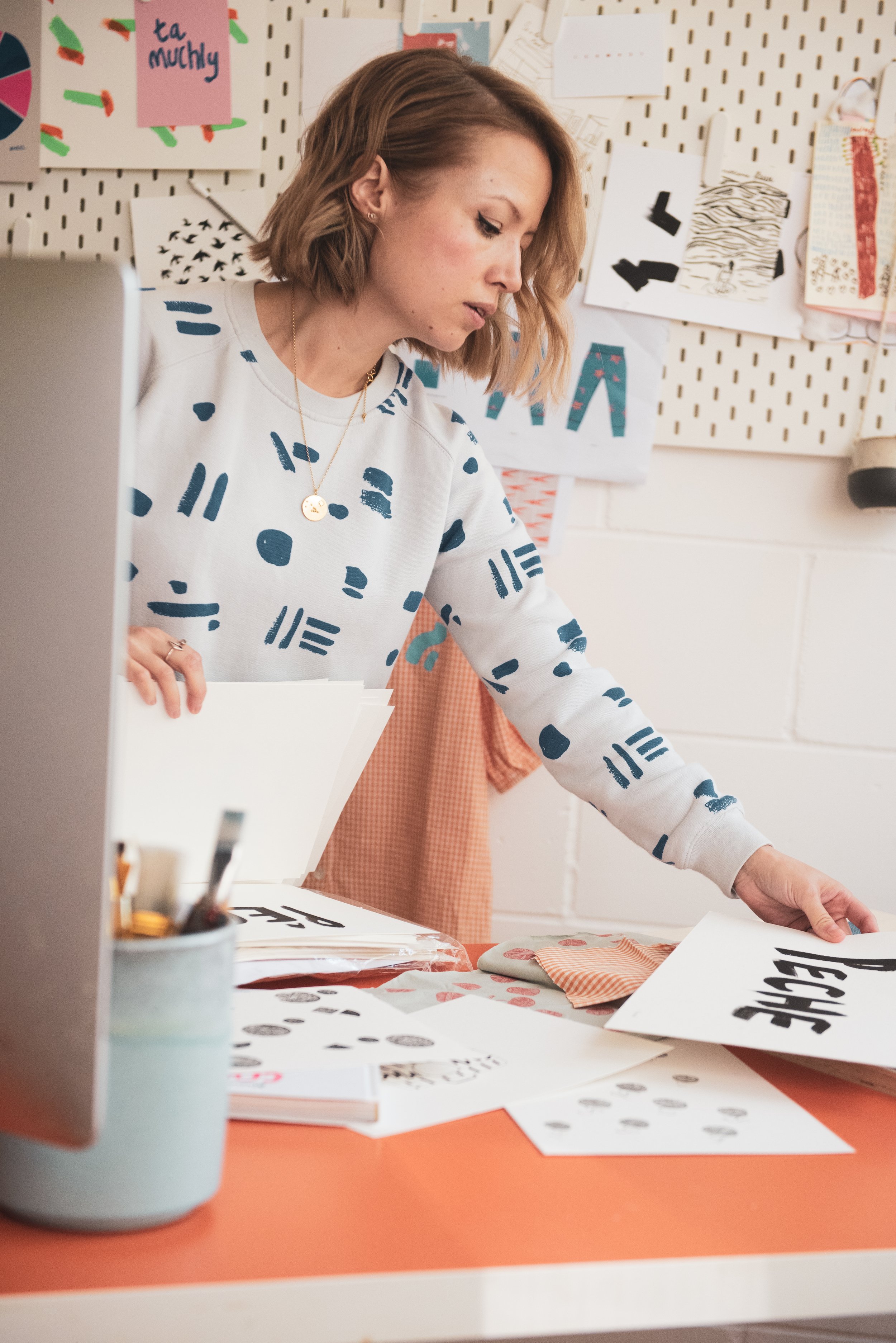 Maker Sarah Birchall of Cub and Pudding wears graphic sweatshirt in her studio