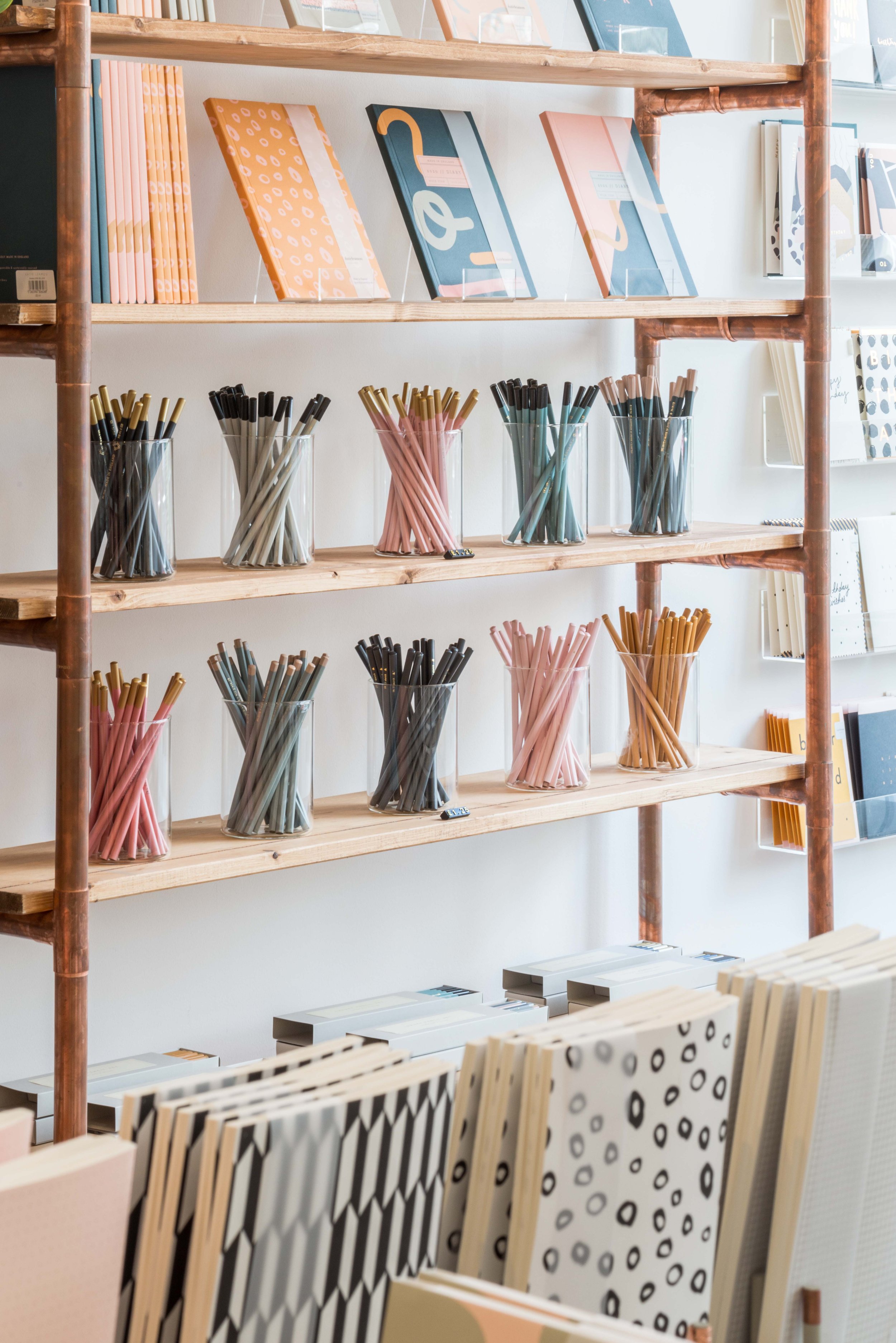 Shop shelving with pretty pencils and notebooks on display
