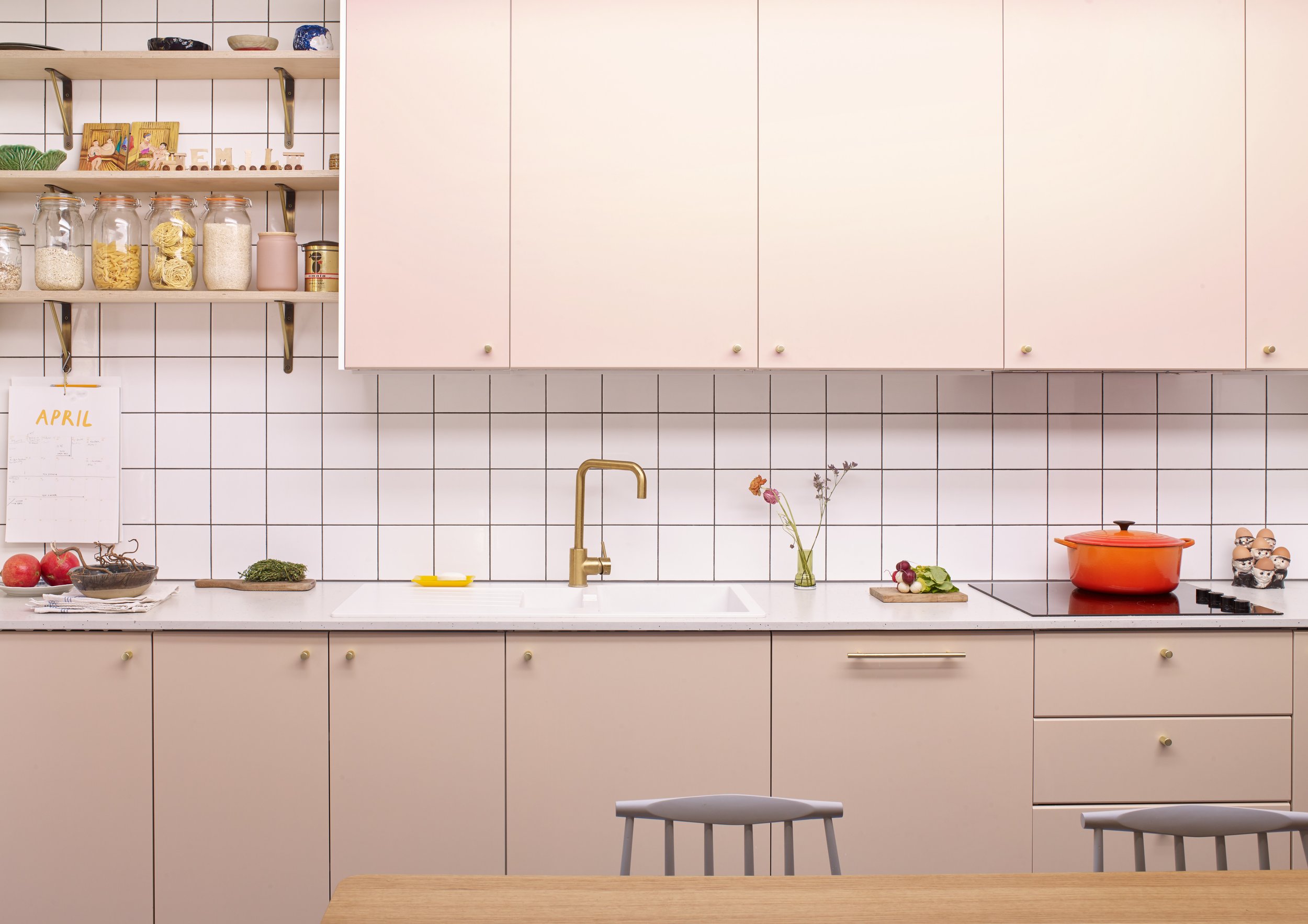 Pink kitchen with white square tiles & brass tap