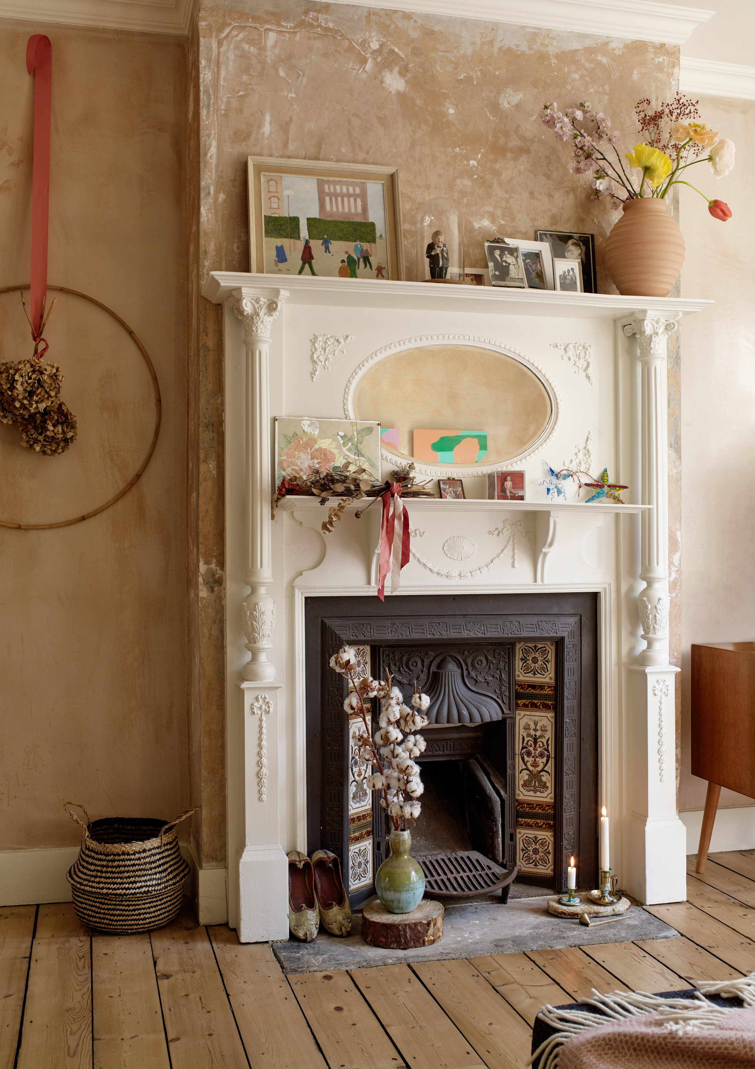 Ornate Victorian fireplace with bare plaster walls