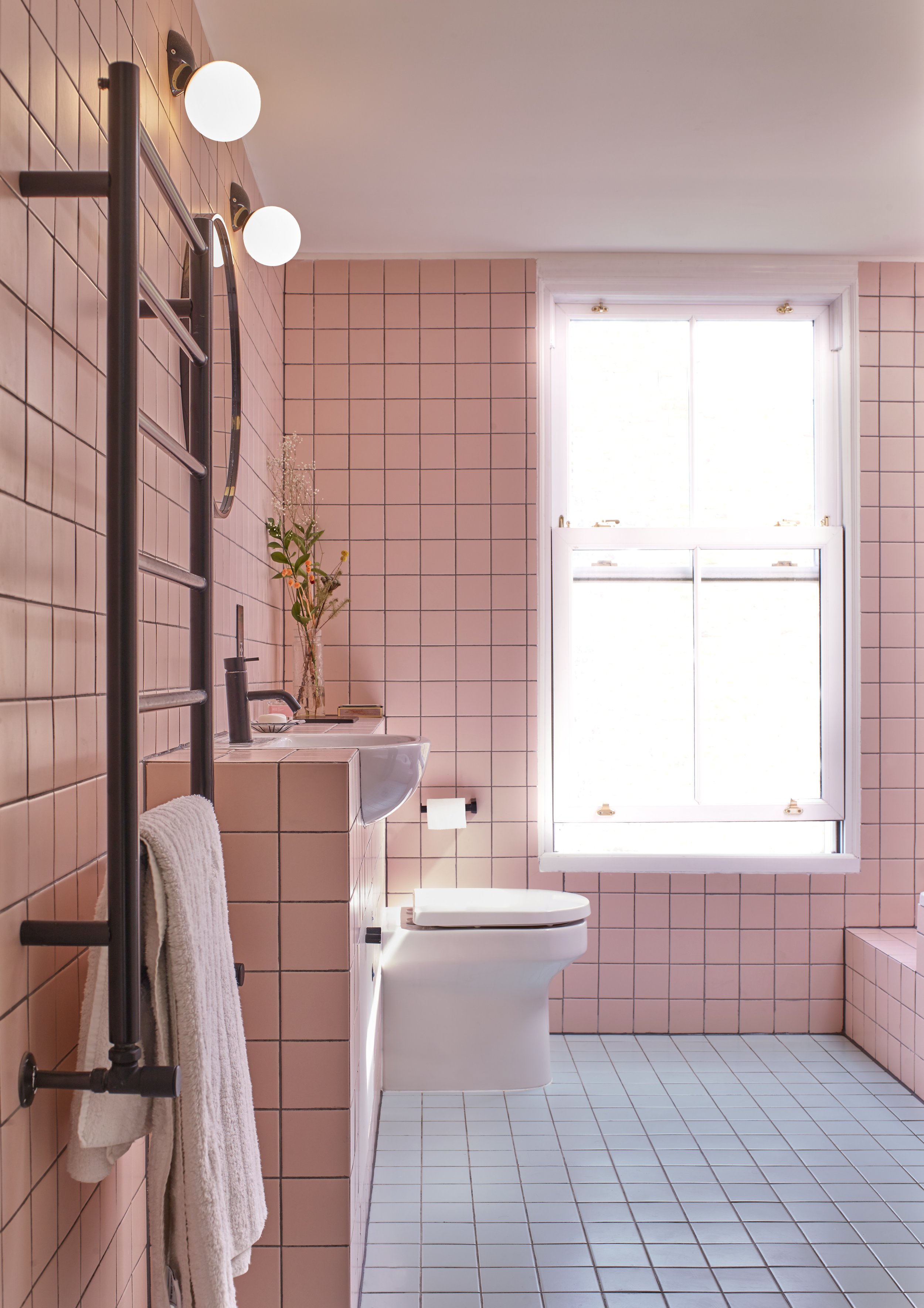 Bathroom with pink wall tiles and green floor tiles,