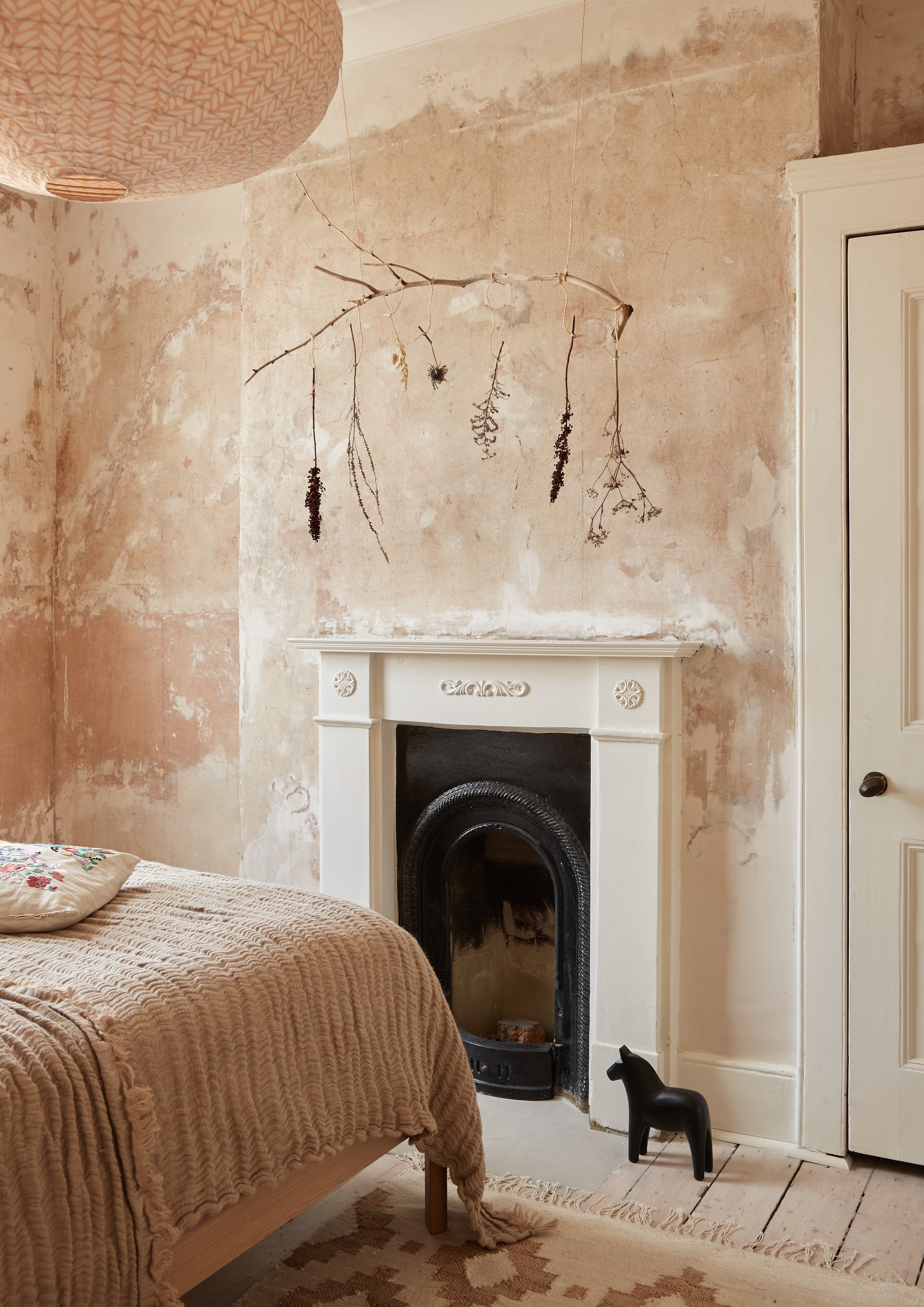 bare plaster wall in bedroom with Victorian fireplace