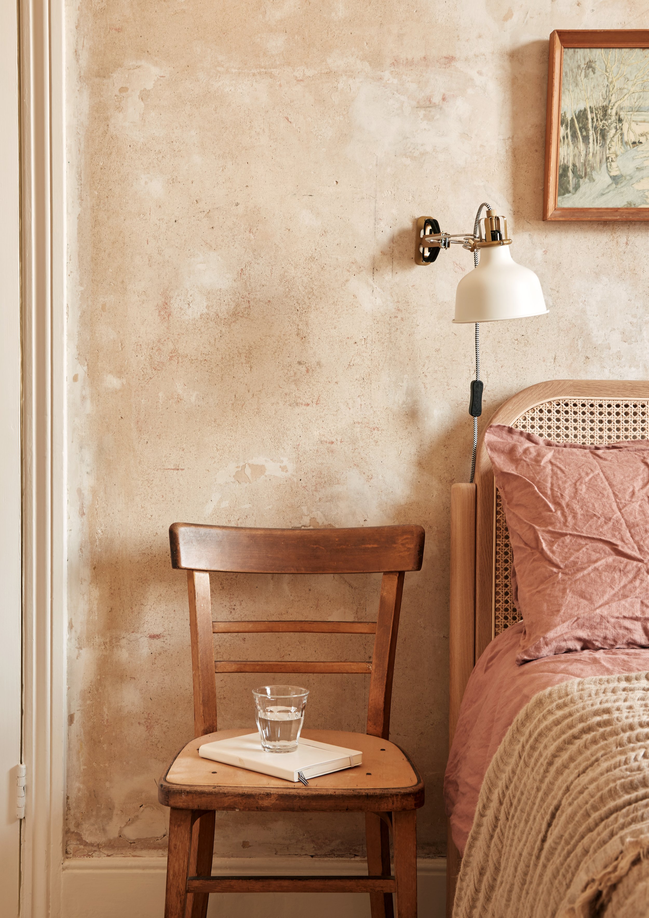Bare plaster walls in bedroom - chair as bedside table