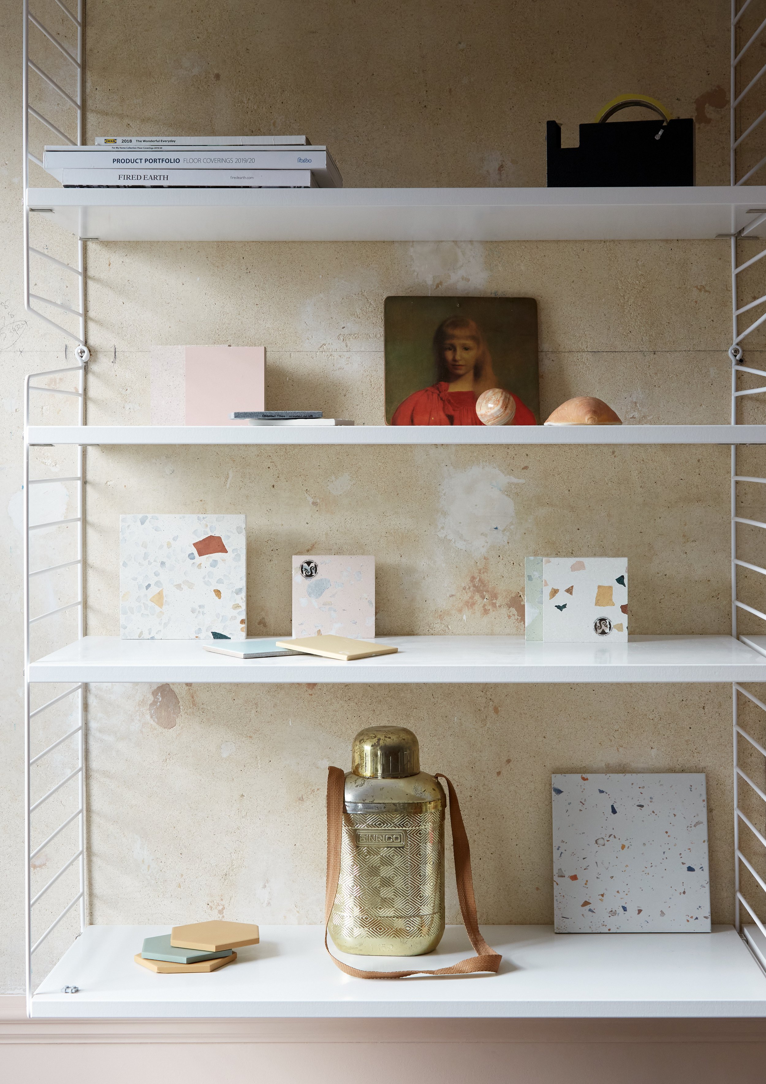 Carefully styled String shelving with vintage finds and terrazzo tiles displayed
