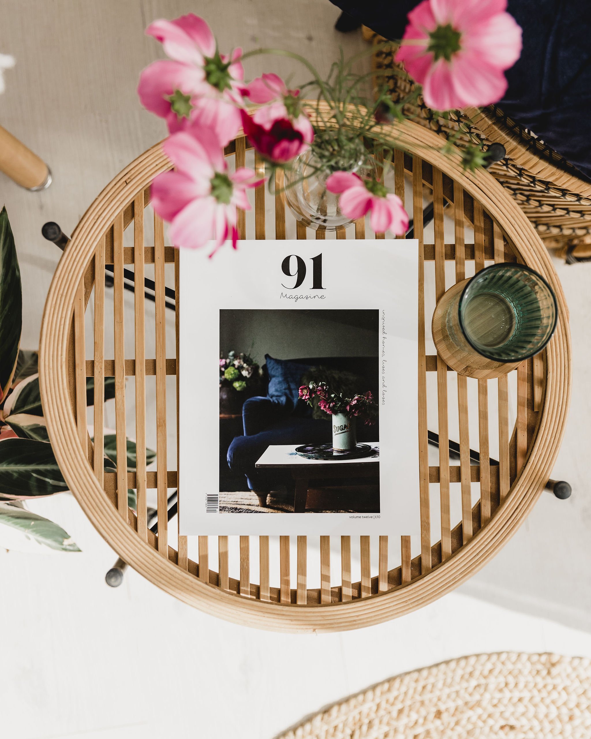 Print copy of 91 Magazine on wooden slatted table with pink flowers