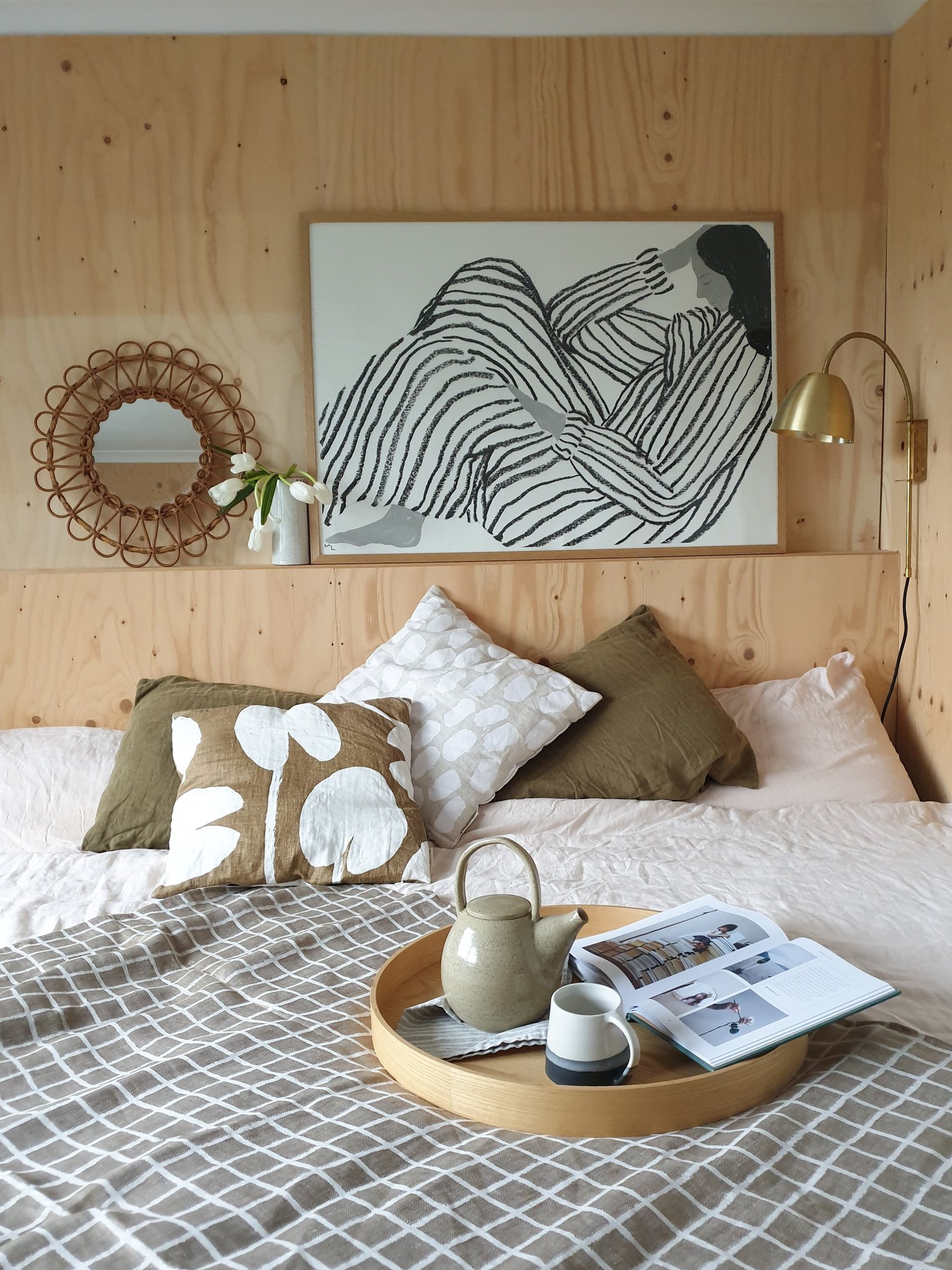 bedroom with bed and black and white artwork on plywood wall