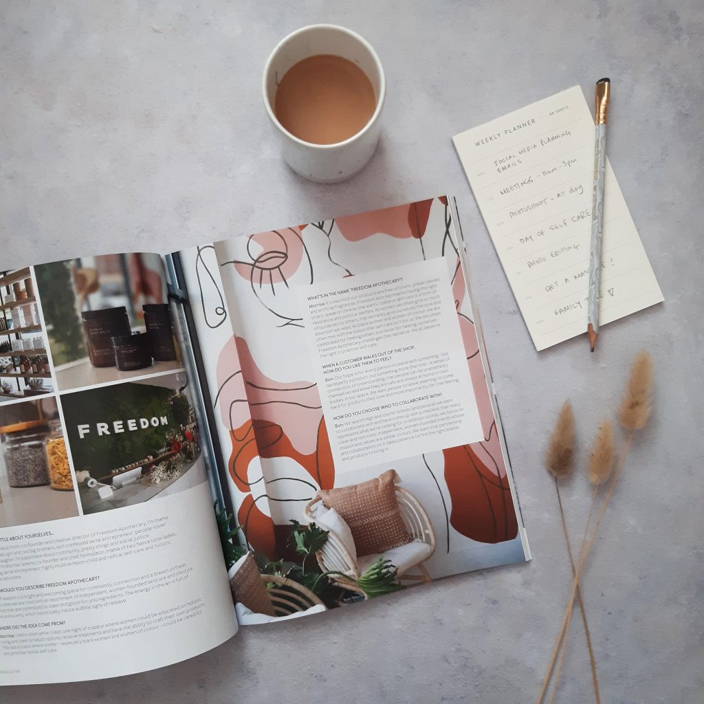 flat lay of a spread of 91 Magazine with a cup of tea and notebook