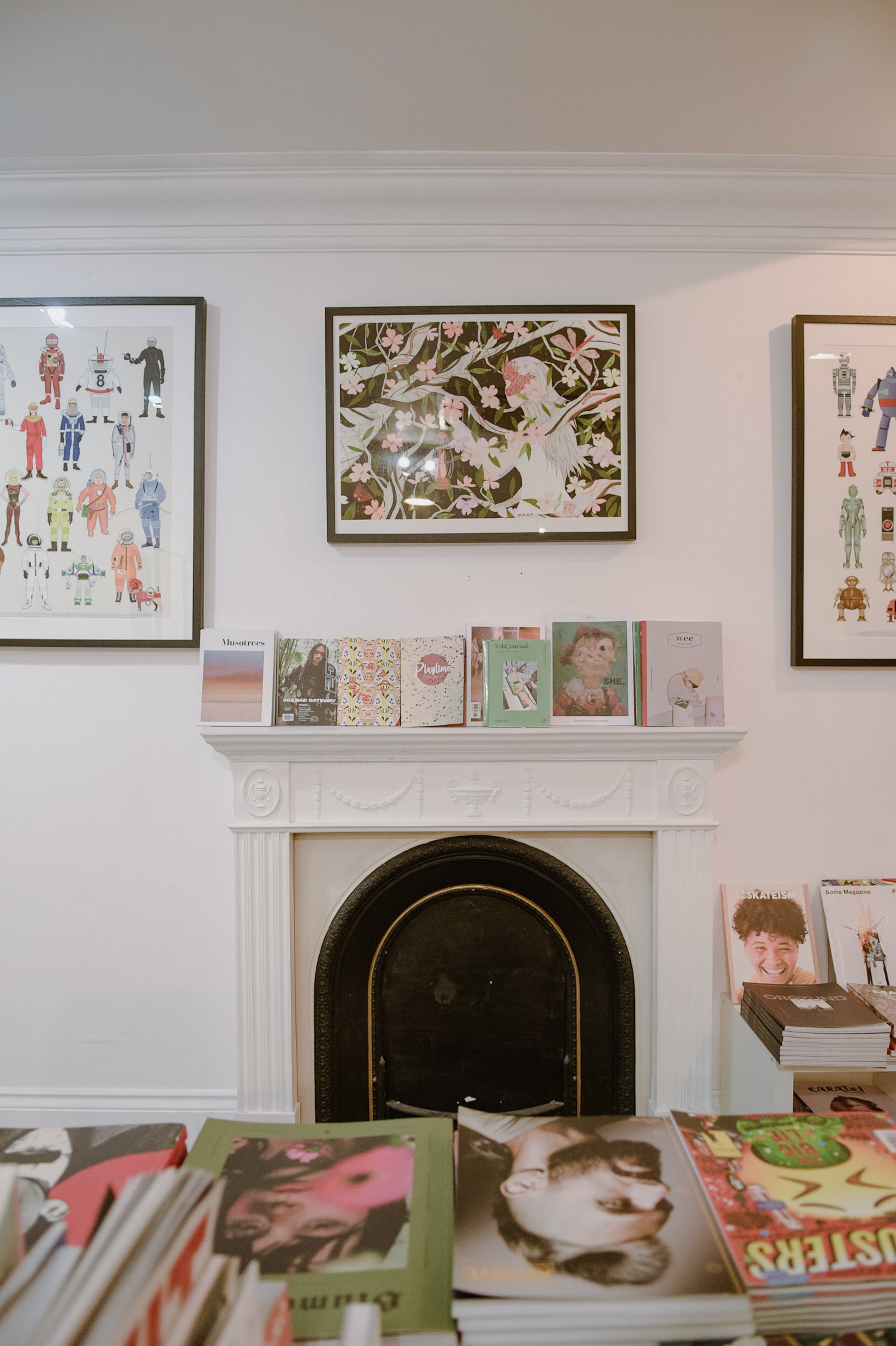 White fireplace and magazines on display in Magma, West London