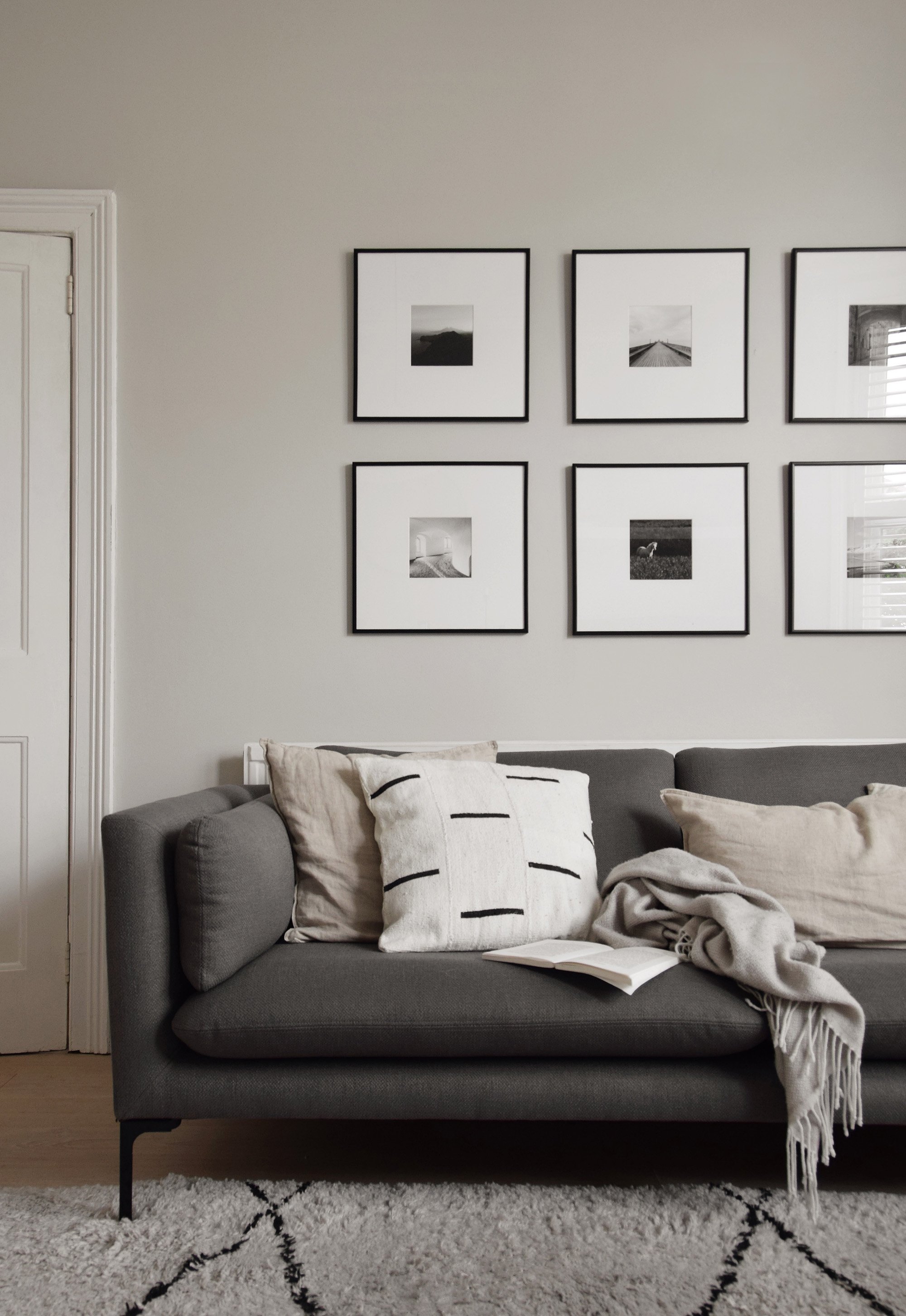 Grey scand-inspired sofa inside the minimalist home of Abi Dare, of These Four Walls Blog