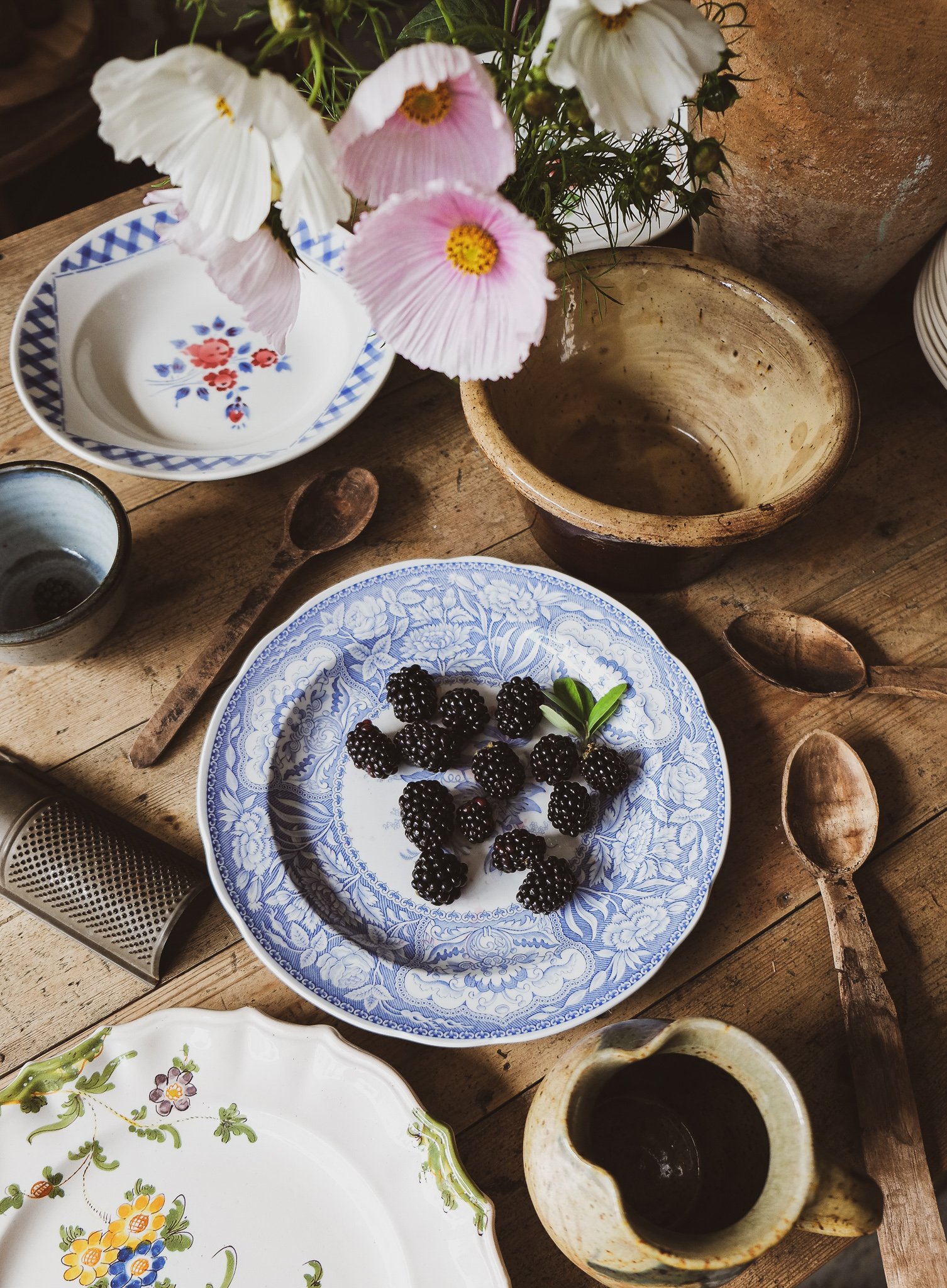 vintage ceramics and wooden spoons on a rustic table