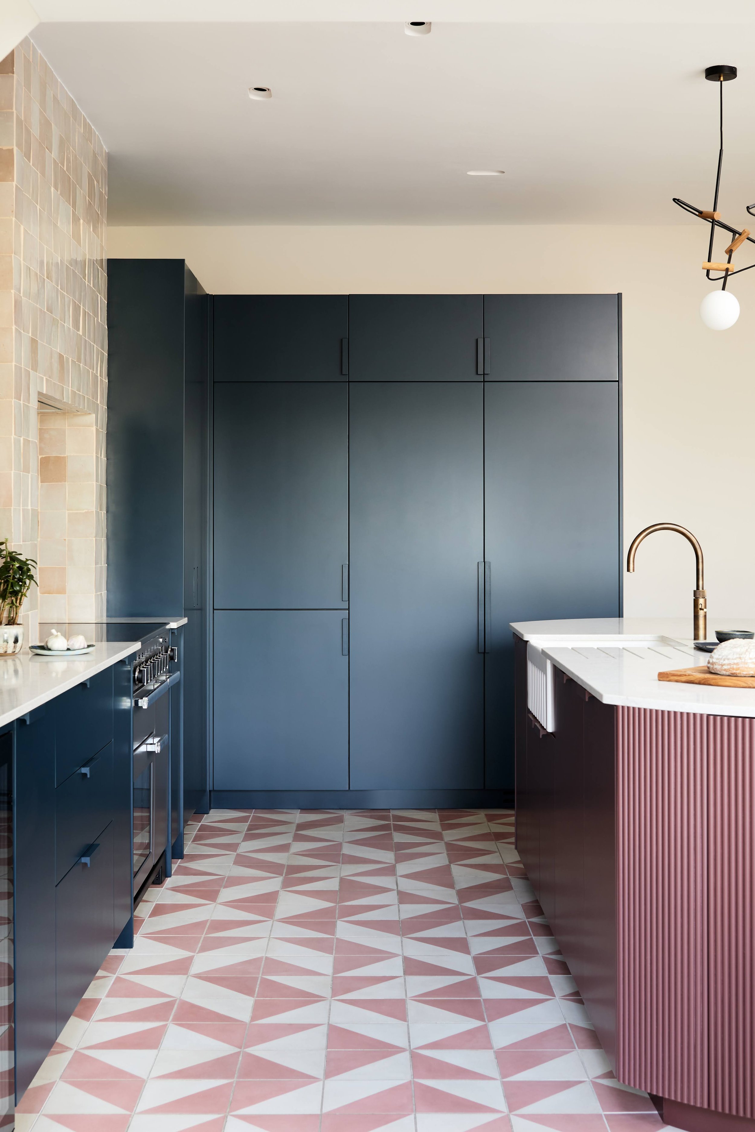 Kitchen with pink floor tiles and dark cupboards