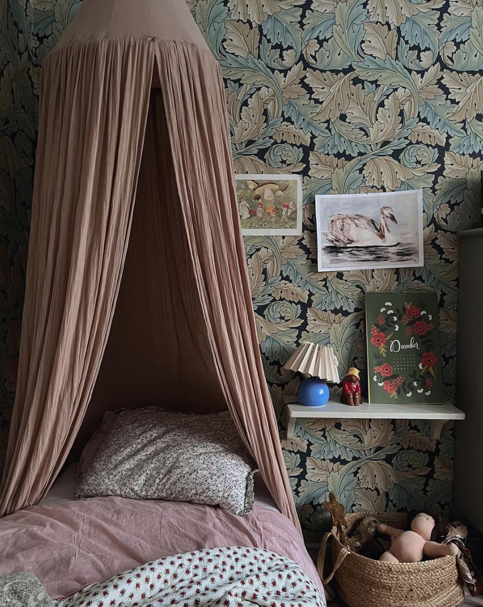 Child's bedroom with fabric bed canopy and floral wallpaper - Swedish style