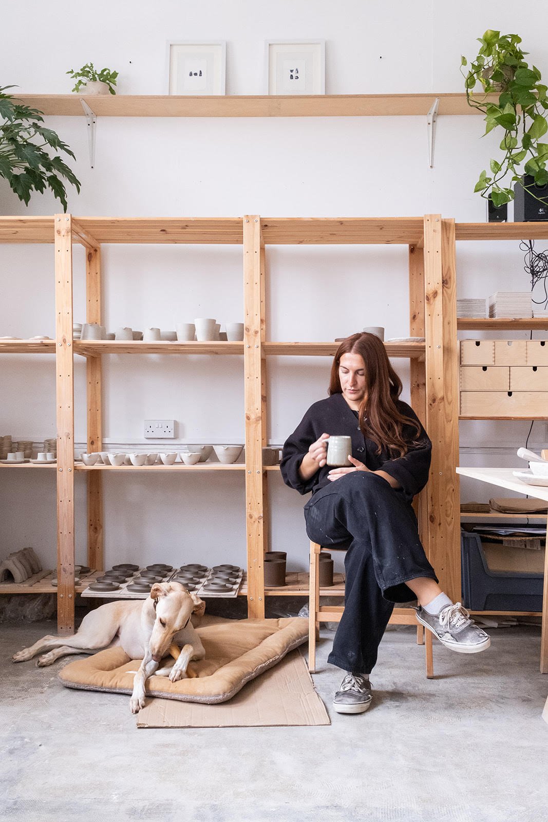 Ceramicist Eleanor Torbati in her studio space alongside her dog