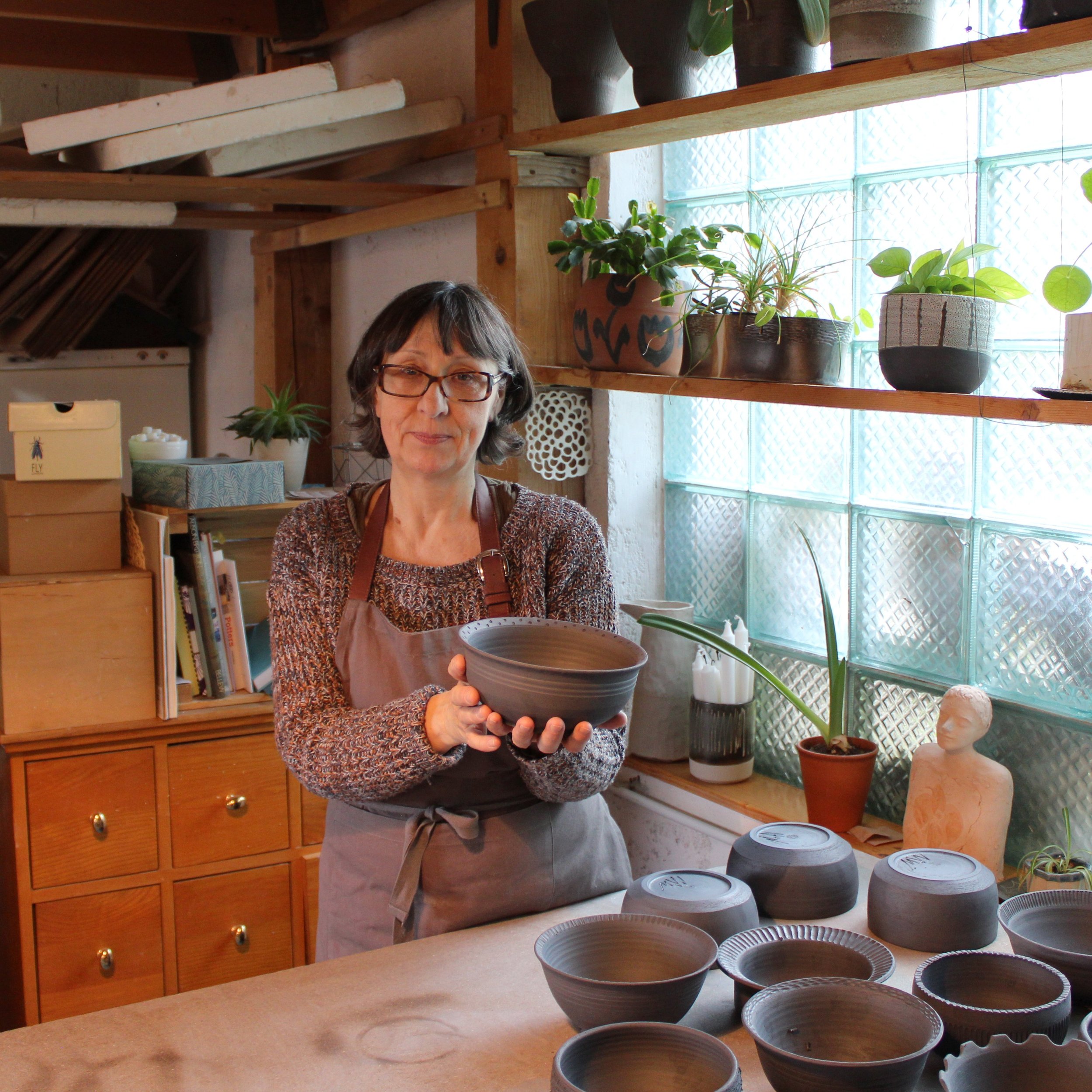 Ceramicist Nives Ratkajec holding a bowl in her studio