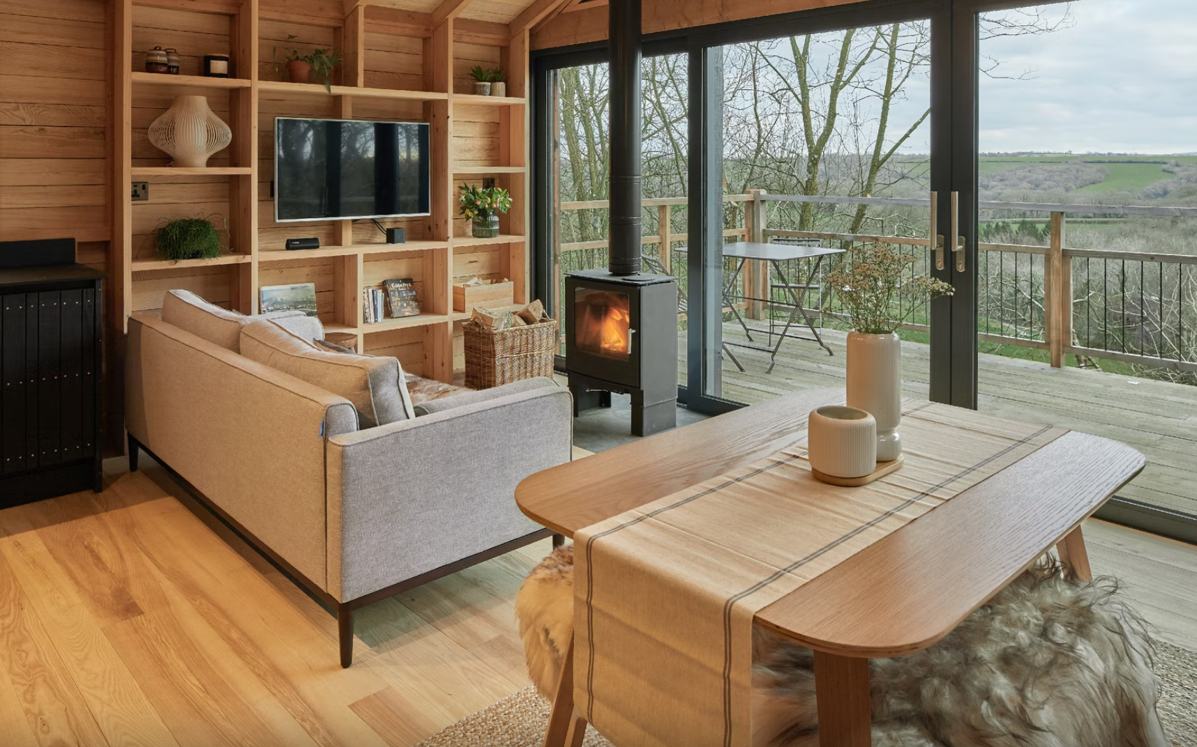 Sofa and woodburner with view Nymetwood Treehouse – Devon