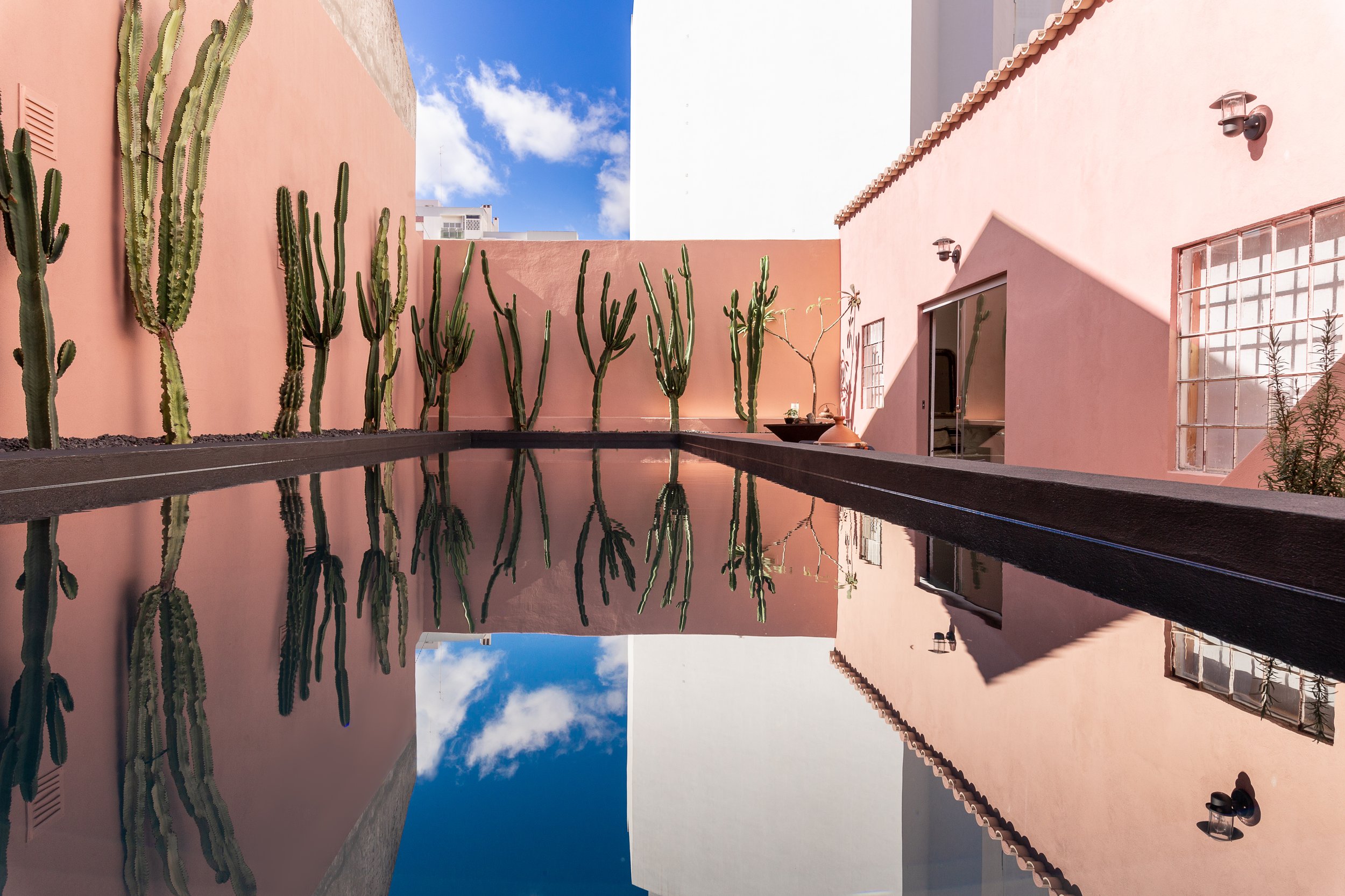 Swimming pool with pink walls and cacti at Ana Ana Artistic Habitat – Algarve, Portugal