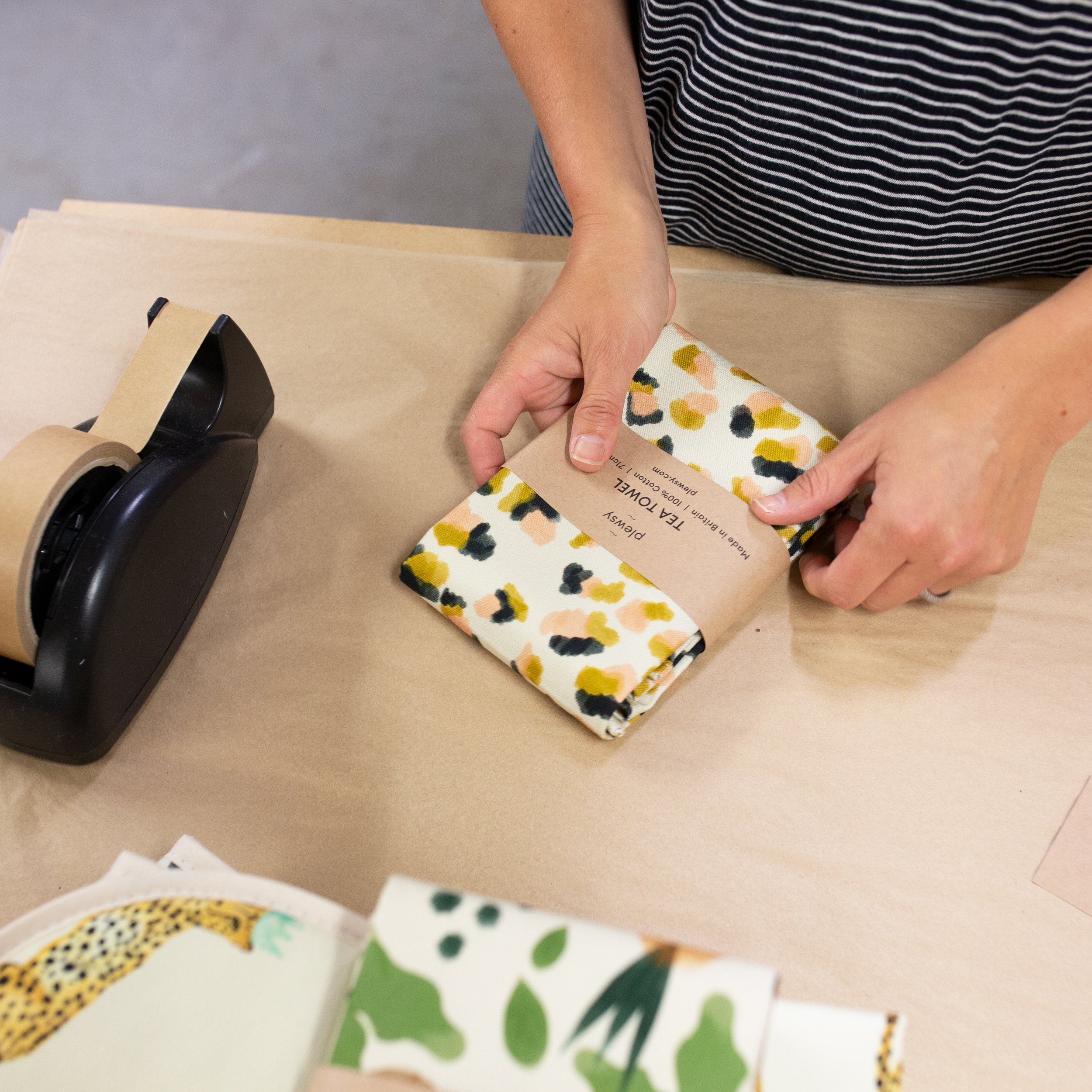 Fiona Fawcett gift wrapping leopard print tea towel in the Plewsy studio in Yorkshire
