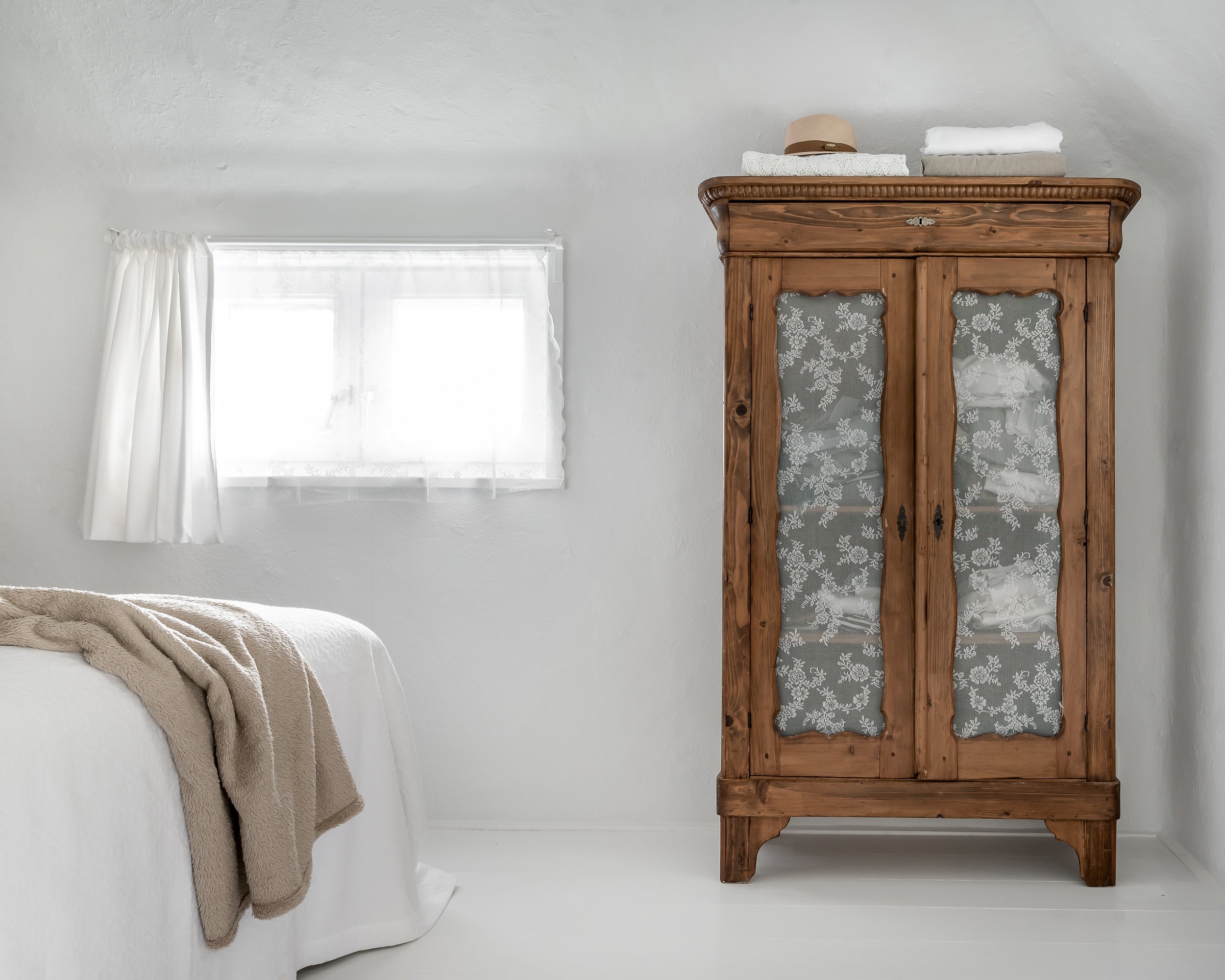 Wooden antique wardrobe in a white bedroom