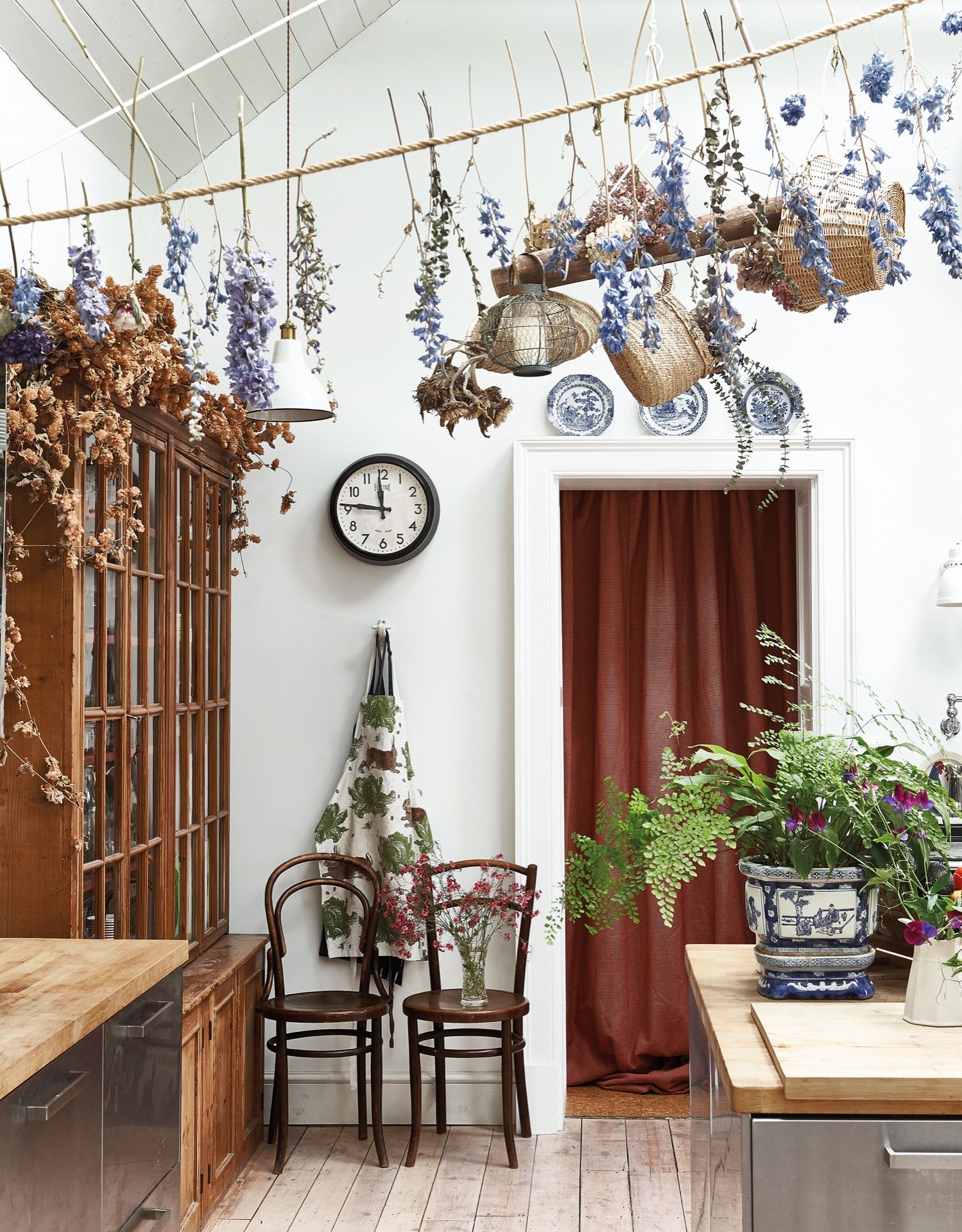 a classic kitchen with dried flowers& baskets hanging up