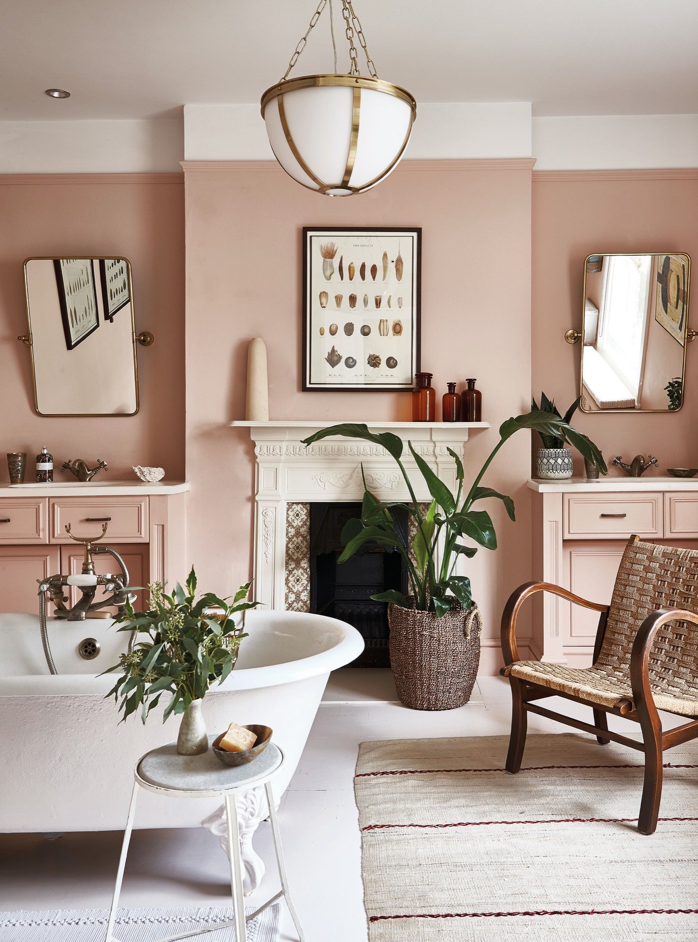 a pink bathroom with roll top bath and vintage furniture