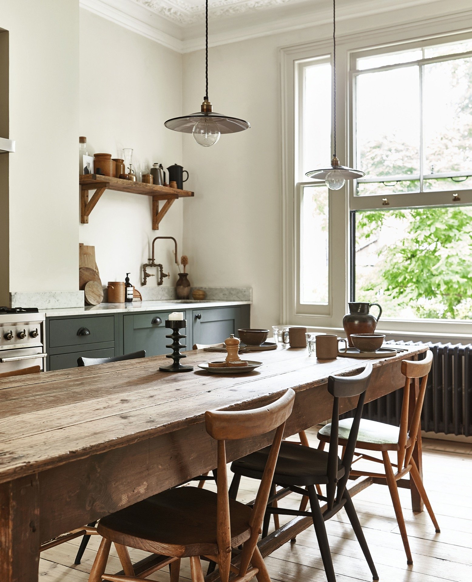 A pared back kitchen interior - old wooden table and open shelving