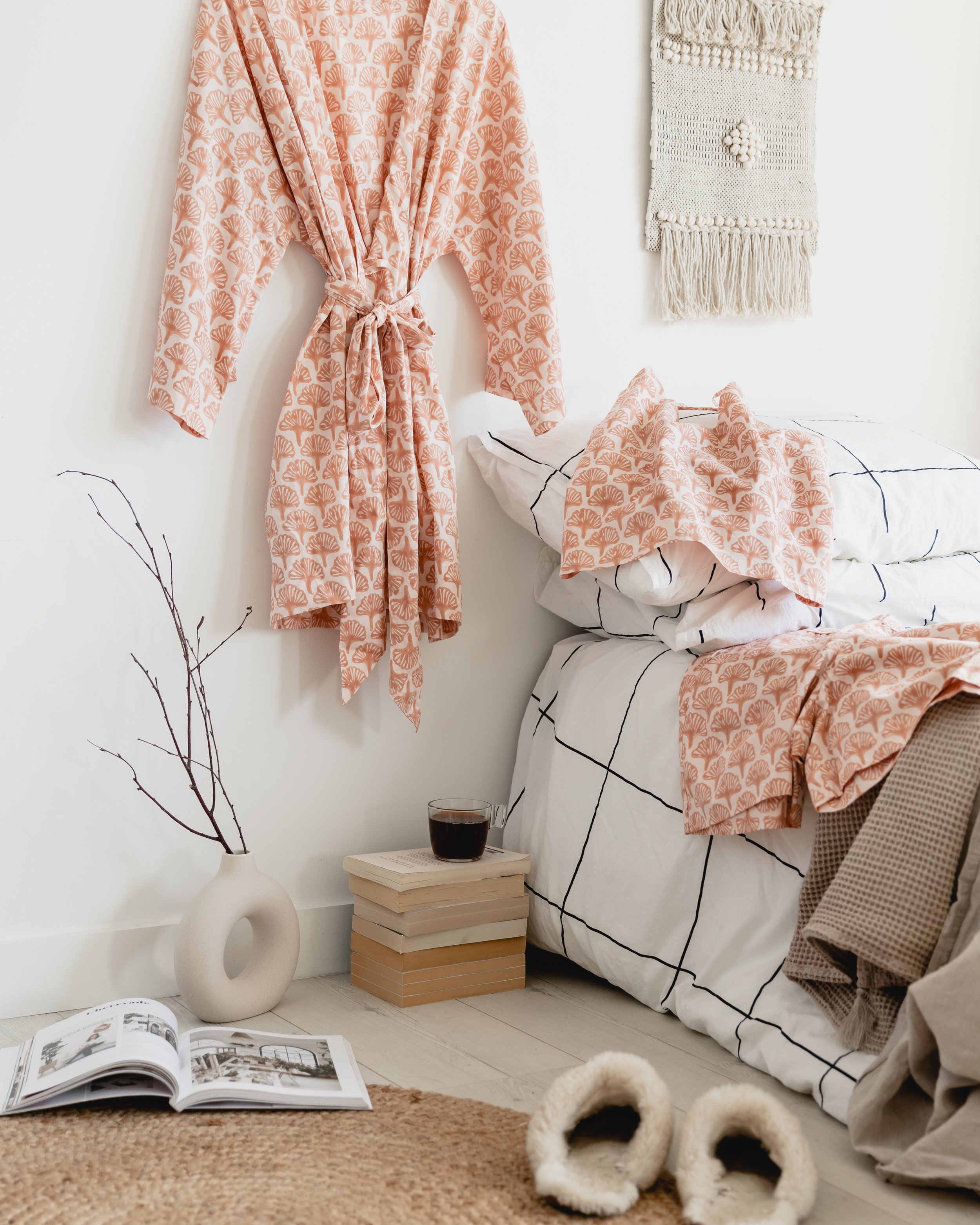 Rho Organic loungewear hanging up by a bed