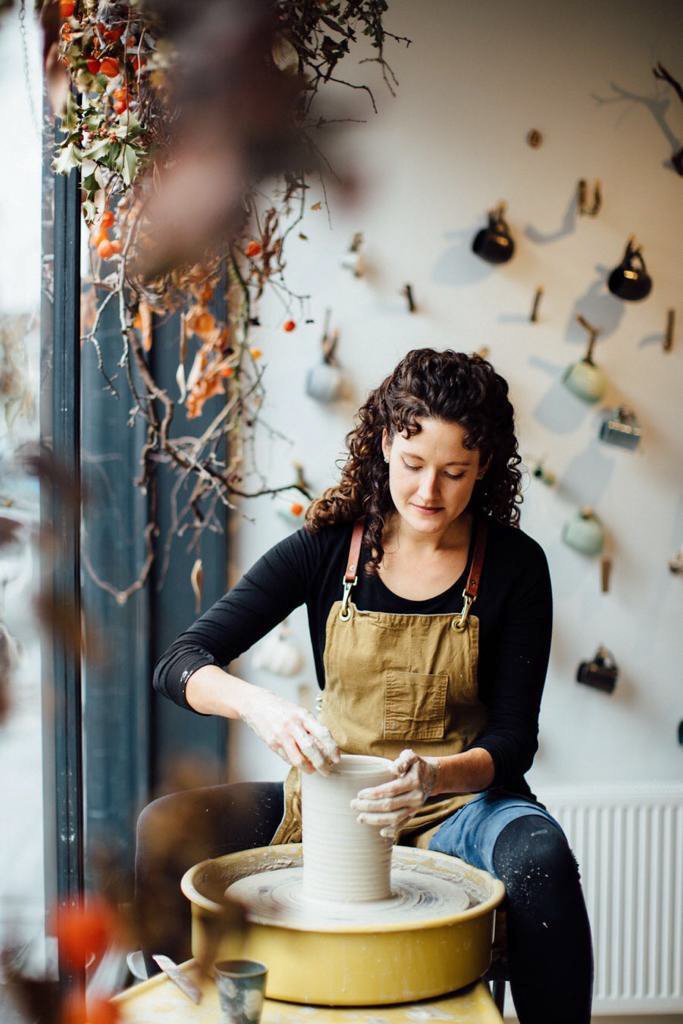 Maker Katie Coston of Illyria Pottery creates her homemade ceramics on her pottery wheel