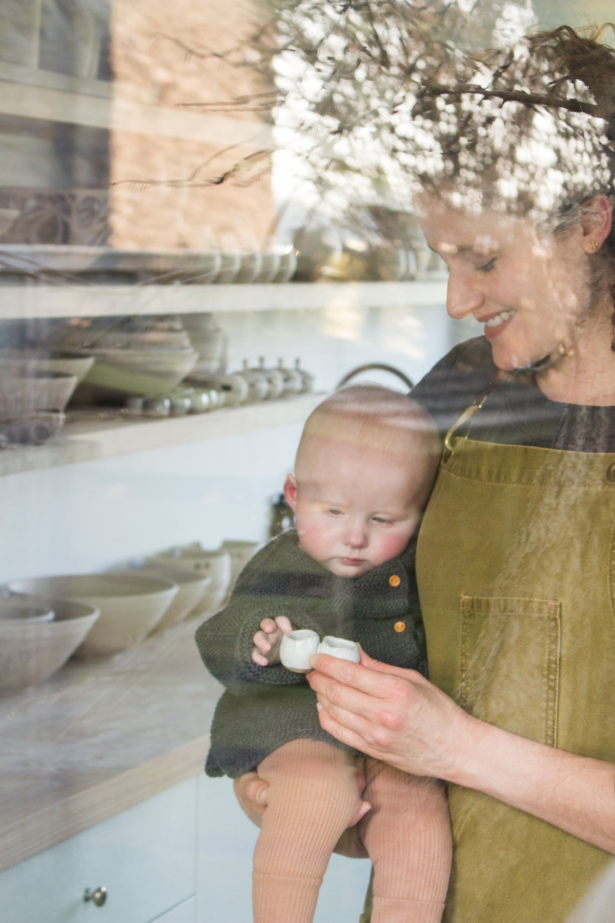Maker Katie Coston of Illyria Pottery with her baby in her Oxfordshire studio