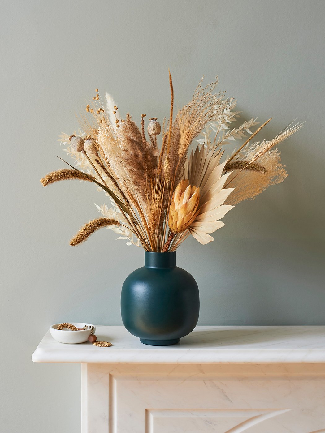 Vase of dried flowers on a mantelpiece