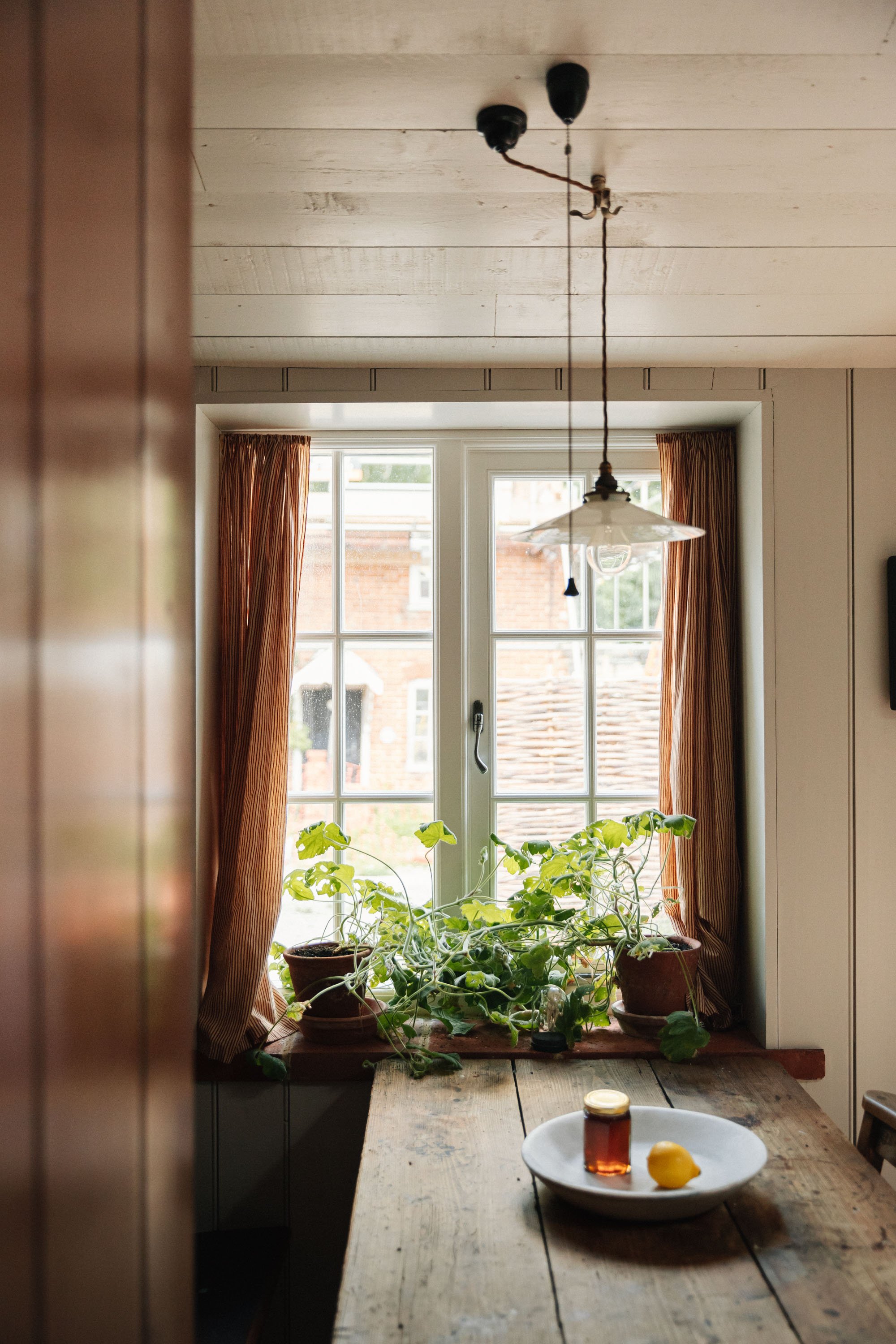 View of window with plants and wooden kitchen table