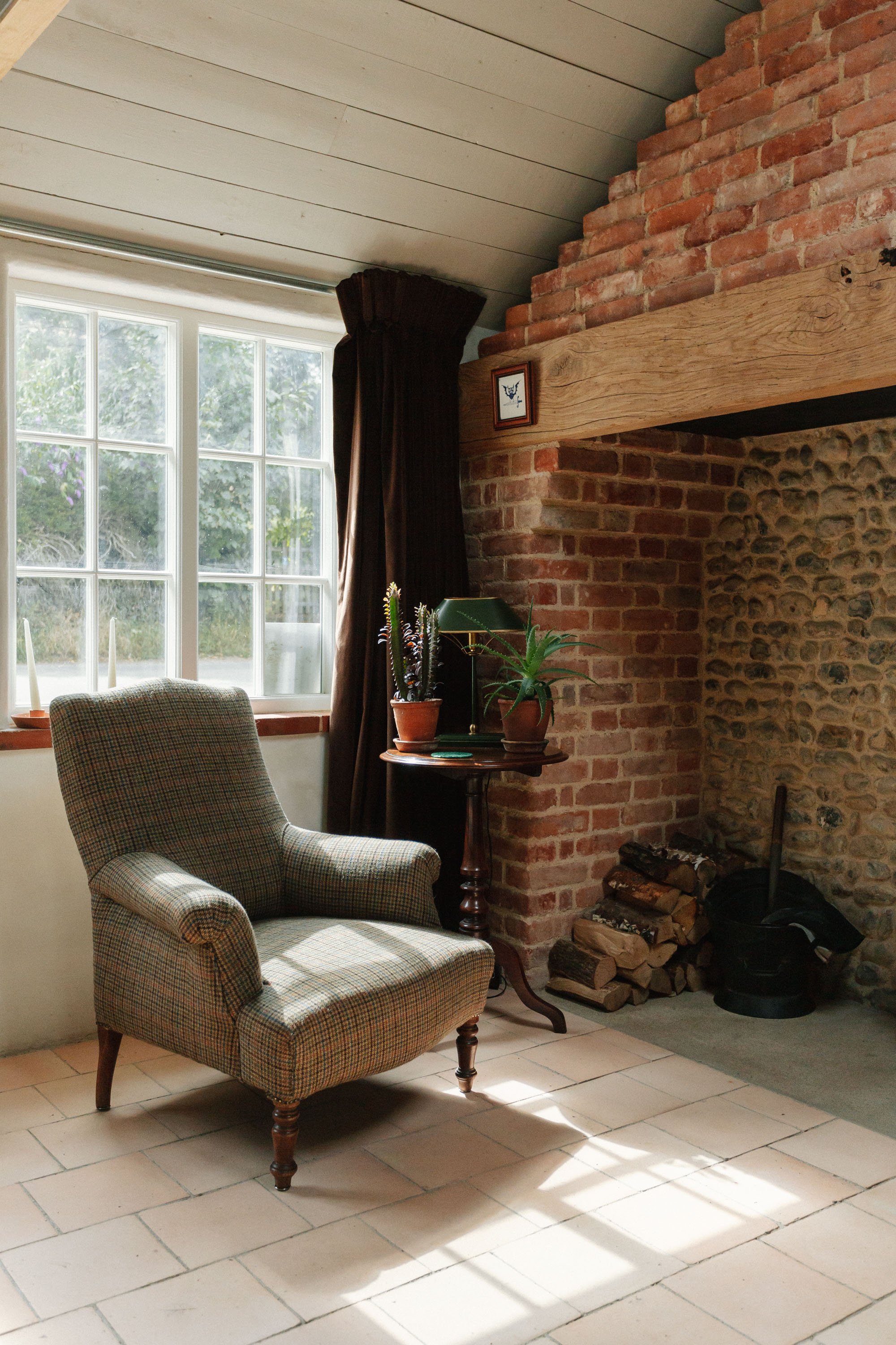 traditional style armchair next to brick fireplace
