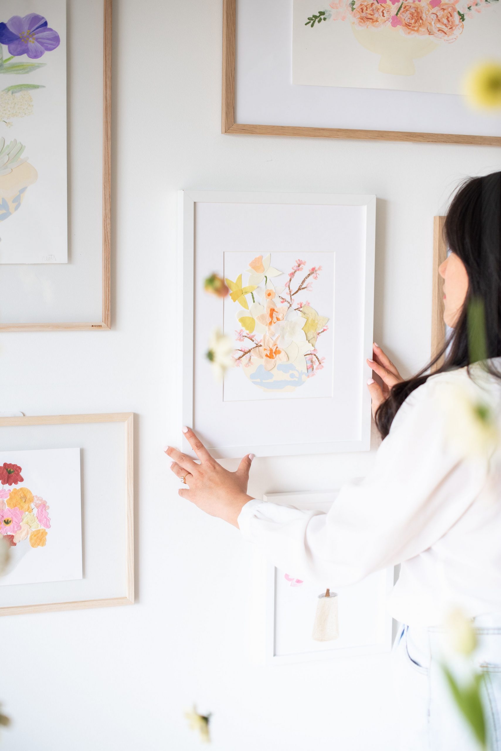 Anita Cheung placing playful Neets print on gallery wall