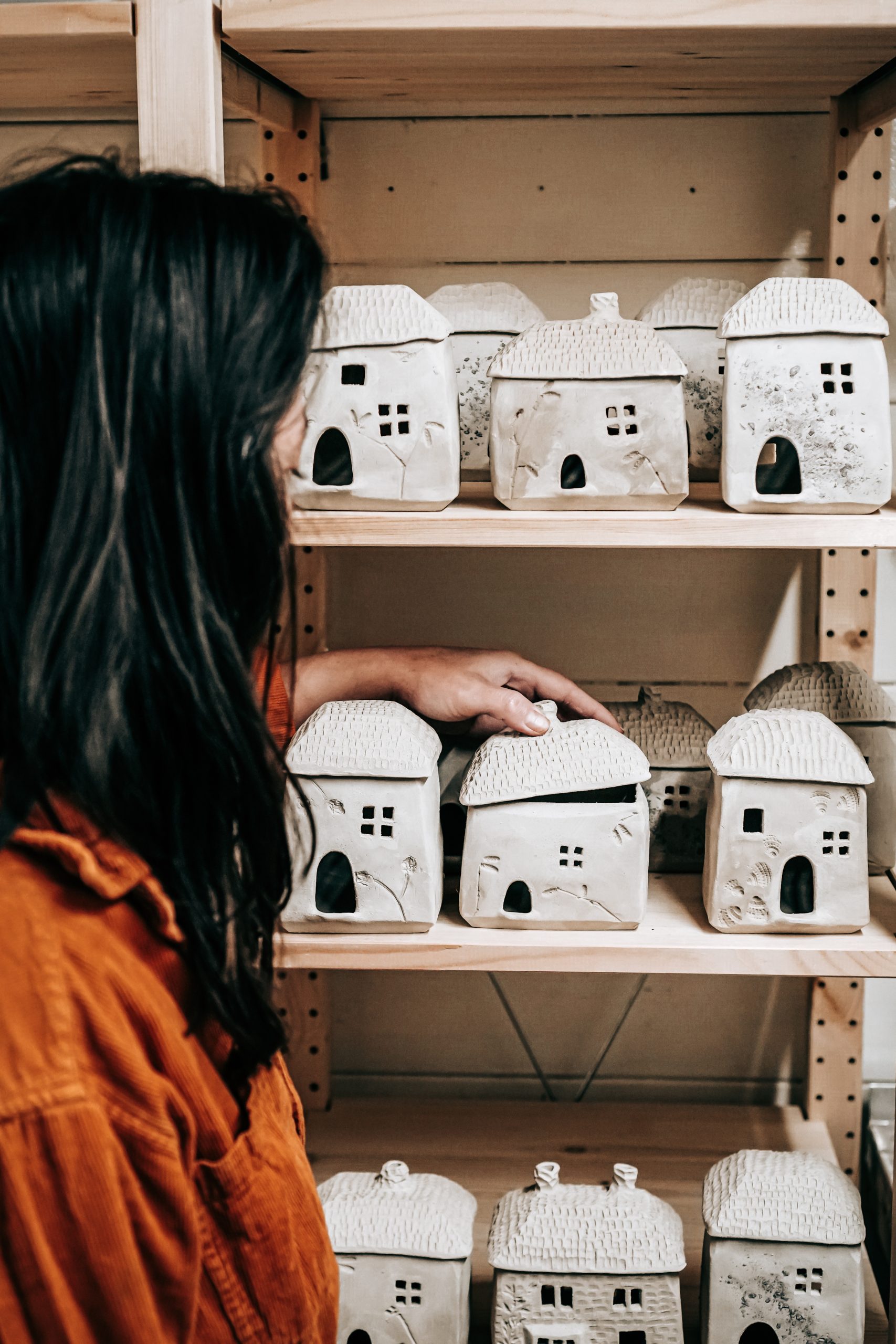 Supatra Marsh of Blank Earth Ceramics with her ceramic cottages in her Suffolk studio