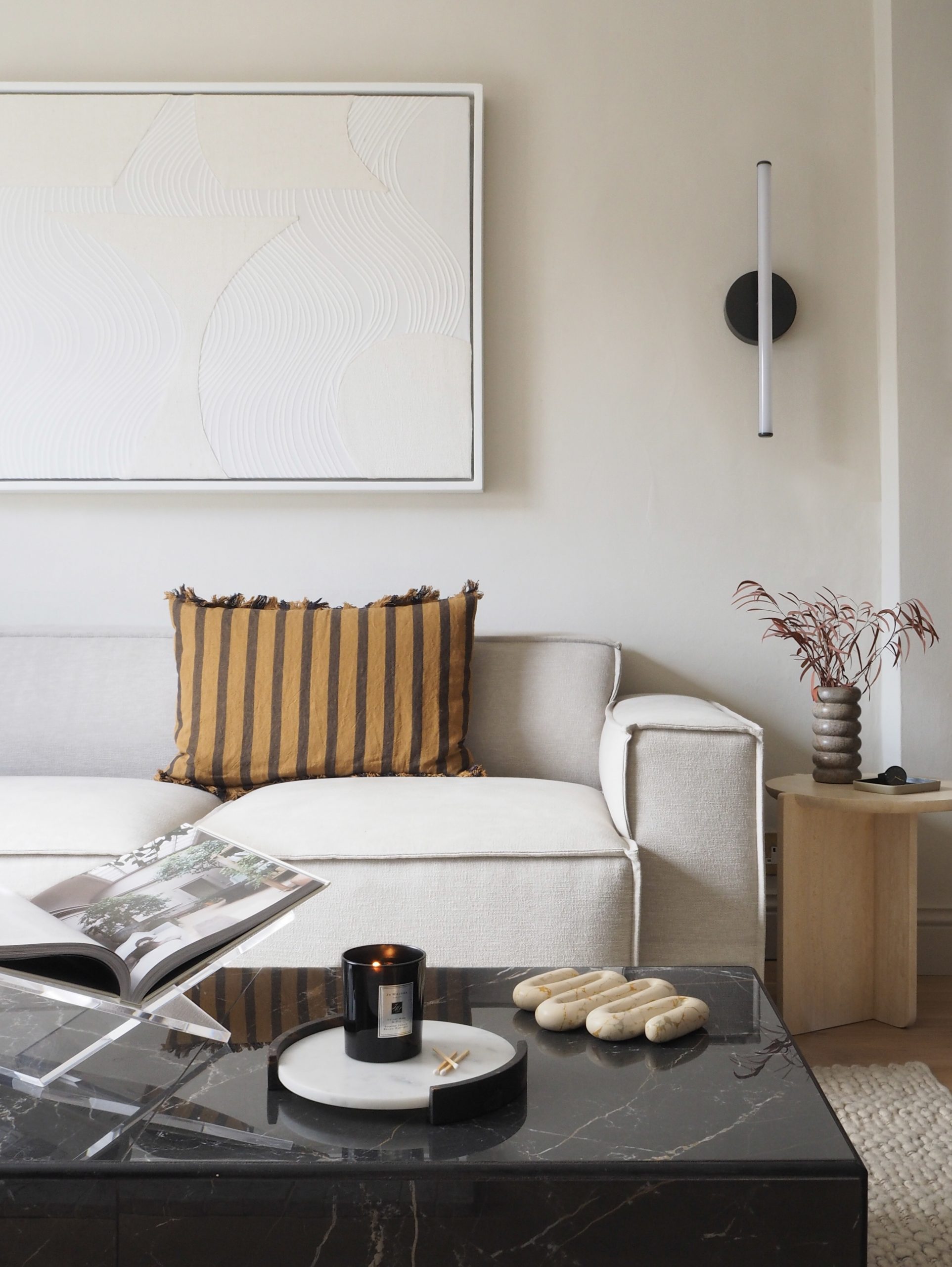Inside Luke Arthur Wells' minimal clean living room with cream modular sofa and black marble table