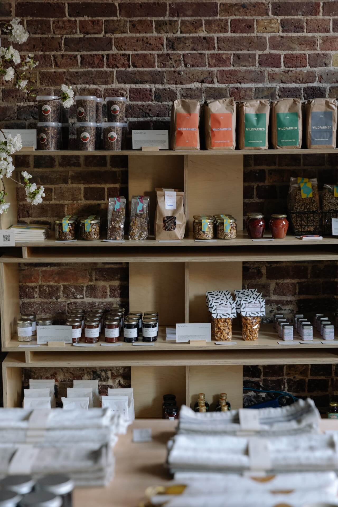 Independent Another Pantry food pop up shop in London with light wooden shelves and exposed brickwork