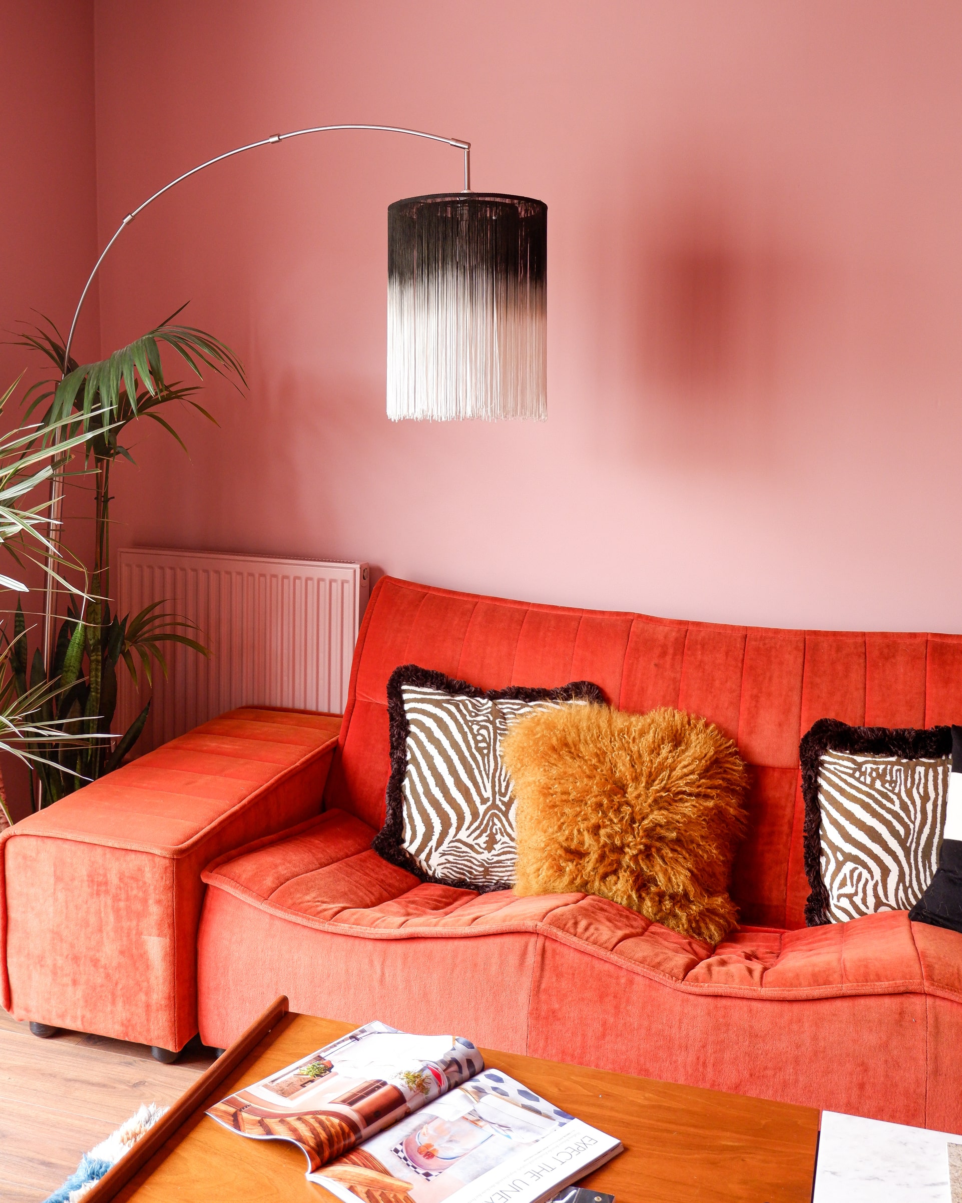 Emma Jane Palin's retro orange sofa with mid-century lamp, inside pink living room