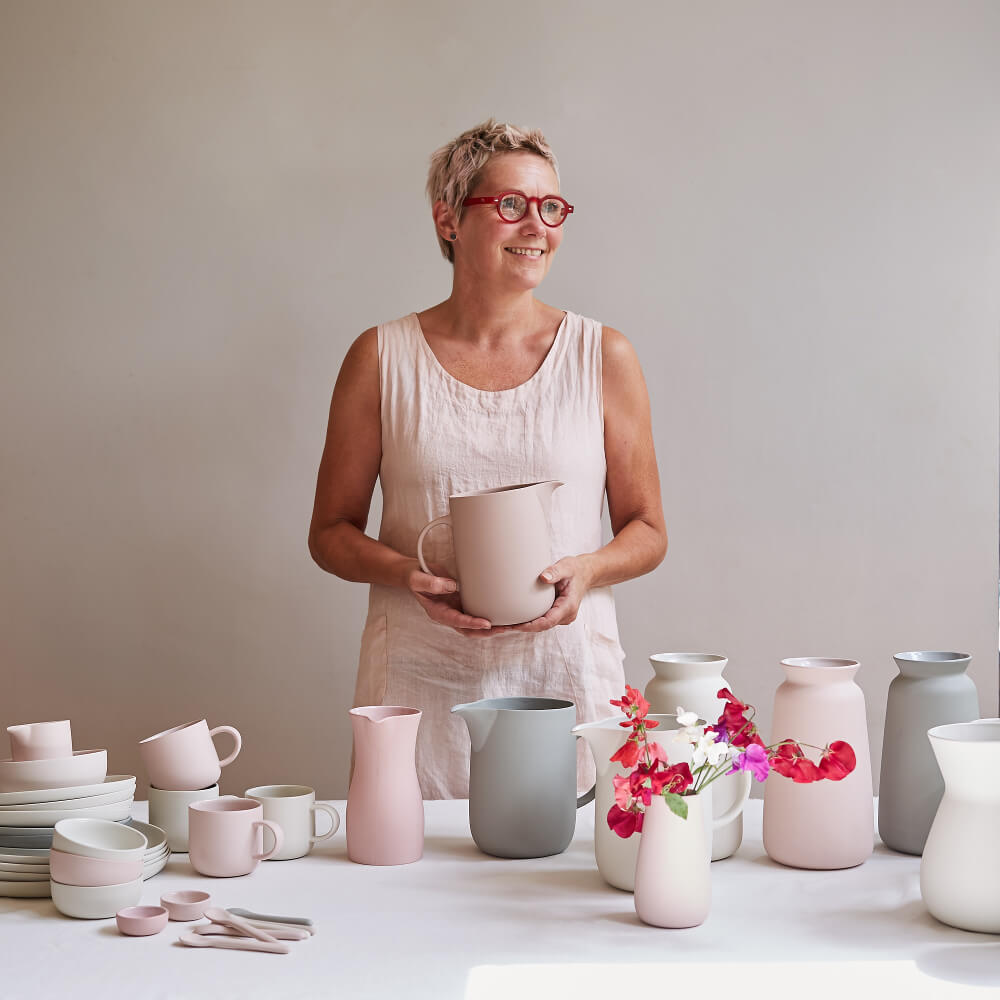 British ceramist Sue Pyrke with white, pink and grey vases, mugs and jugs