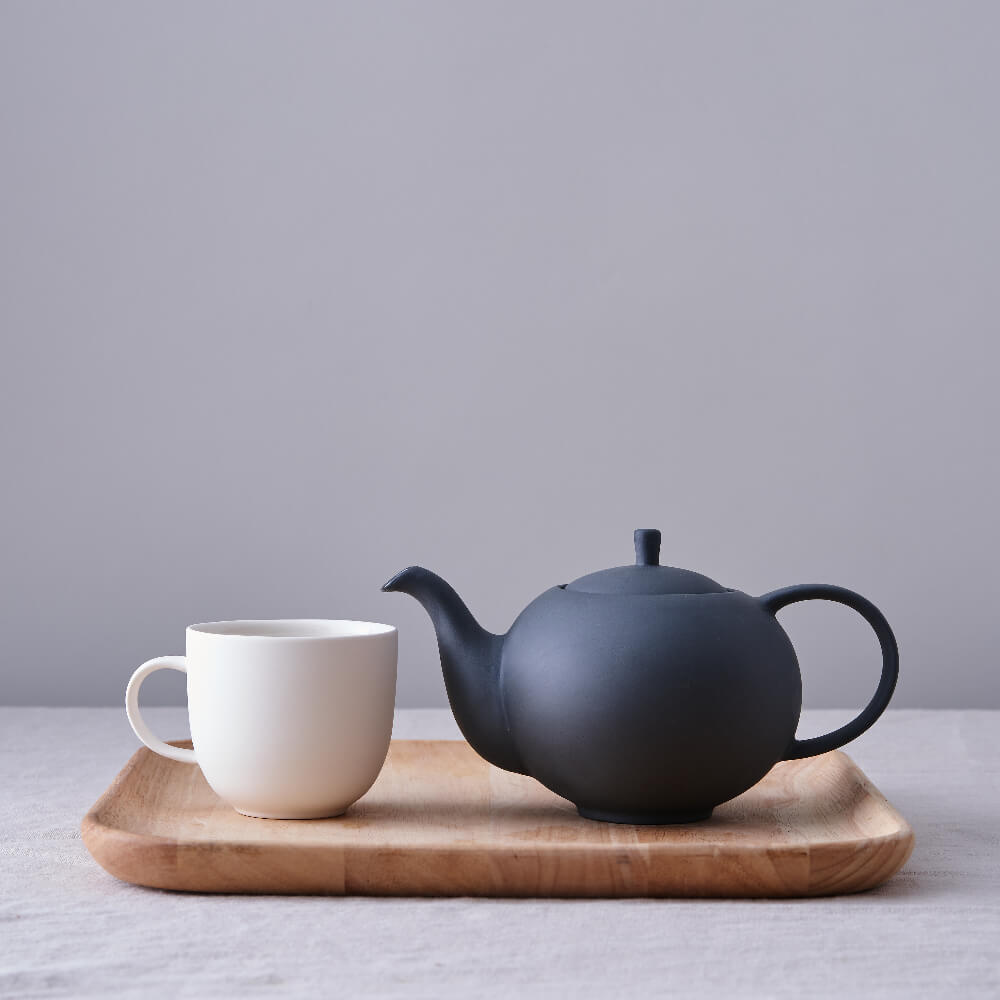 Minimal black and white teapot and mug by British ceramist Sue Pyrke