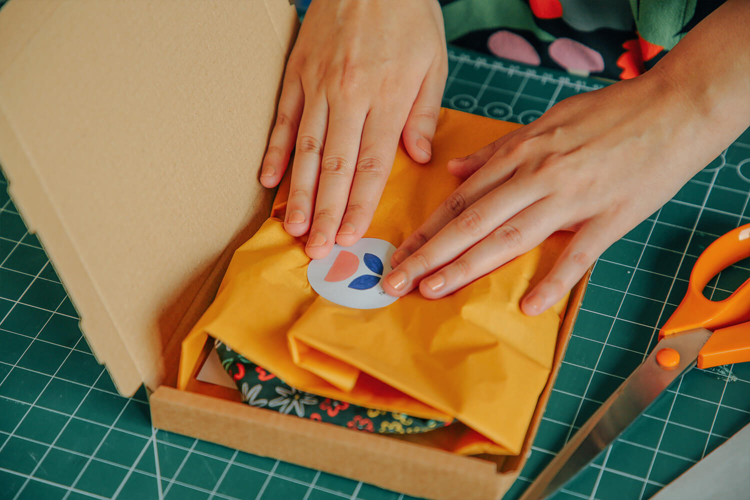 Illustrator and maker Taaryn Brench packing with colourful abstract tissue and packaging