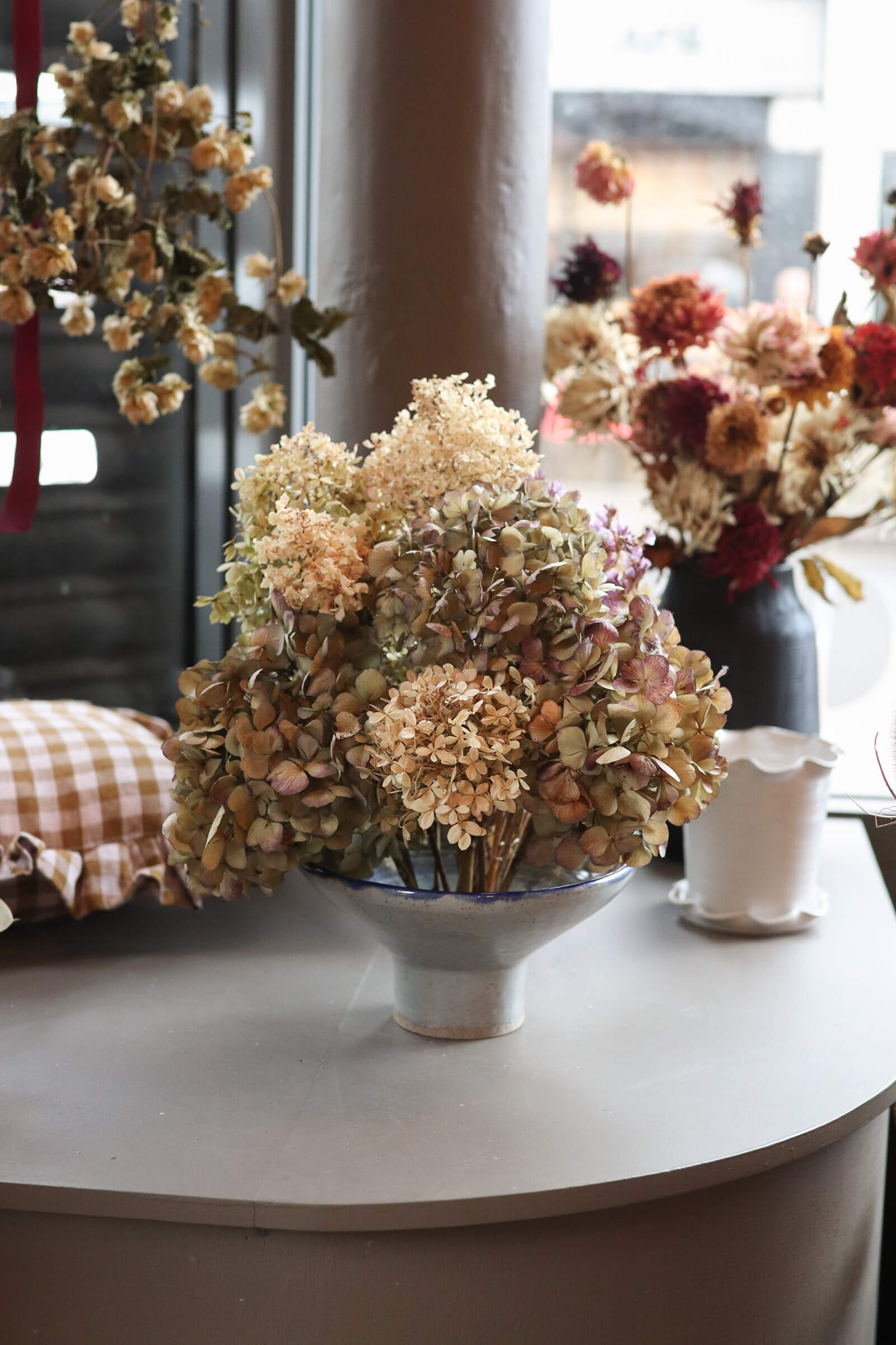 Bohemian interiors and homeware including dried hydrangea and gingham cushions inside independent flower shop Hedge, Birmingham