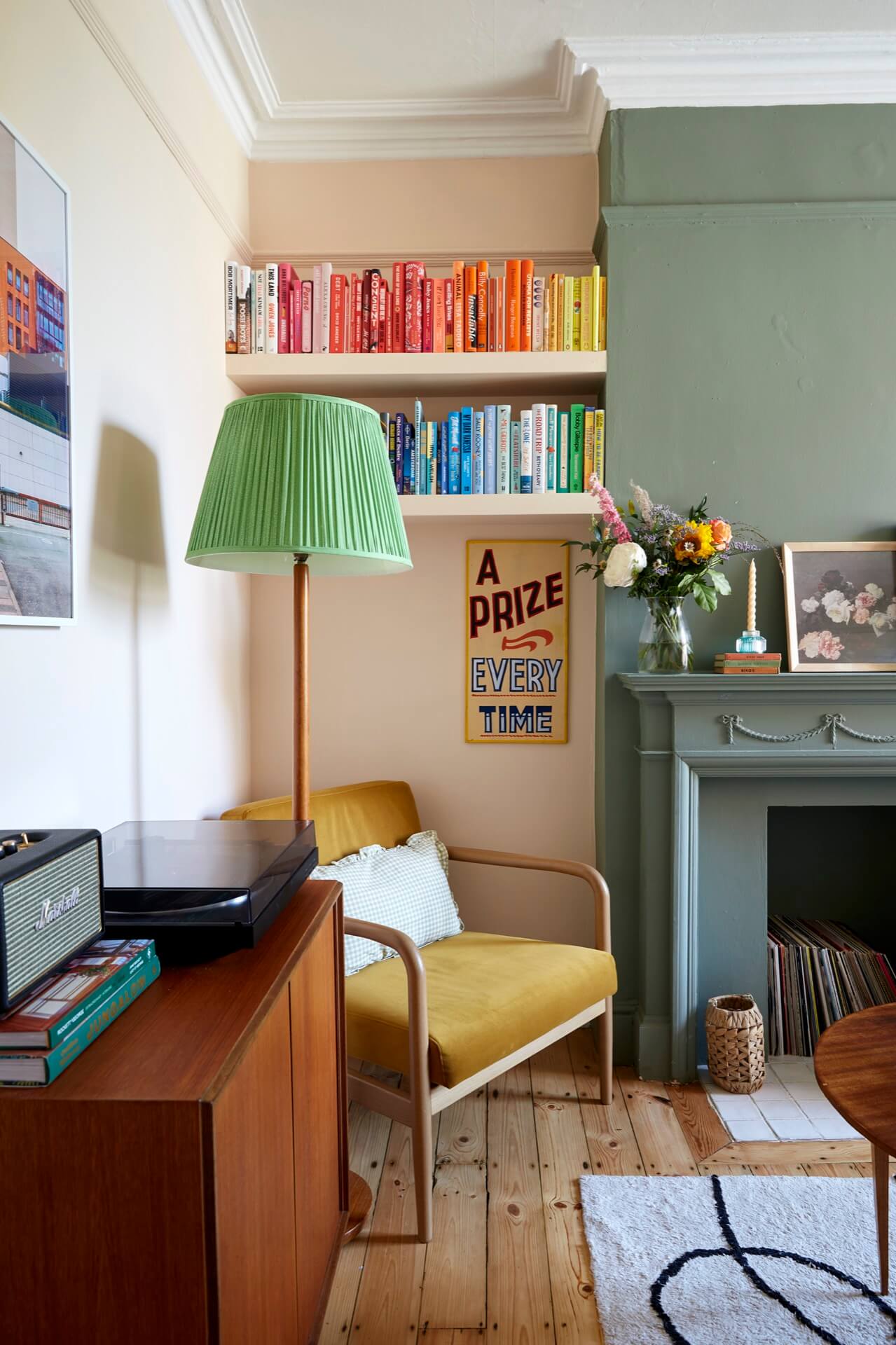 Living room with vintage finds and bookshelves filled with colour-coded books 