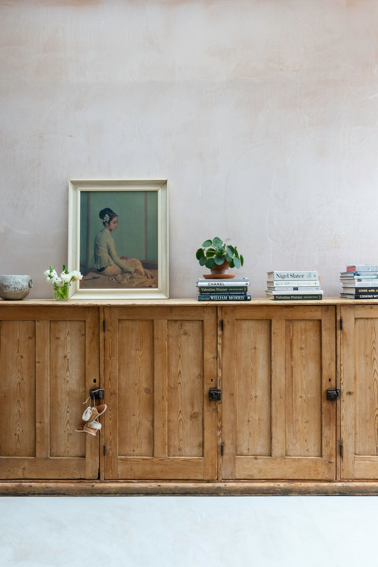vintage wooden cabinet against a bare plaster wall