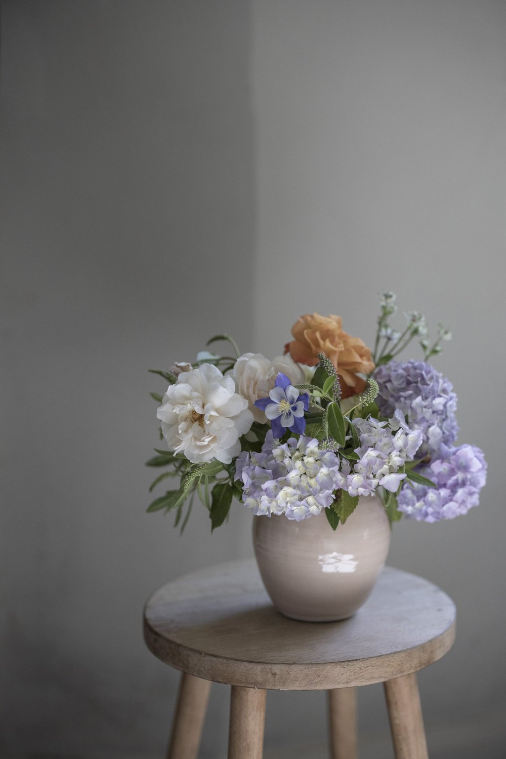 large bouquet of pastel coloured fresh flowers in a porcelain vase by Paper Thin Moon