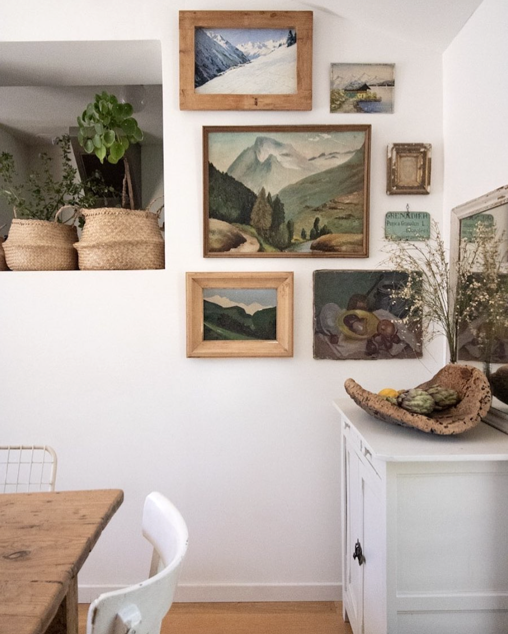 vintage landscape paintings displayed in a light and airy living space