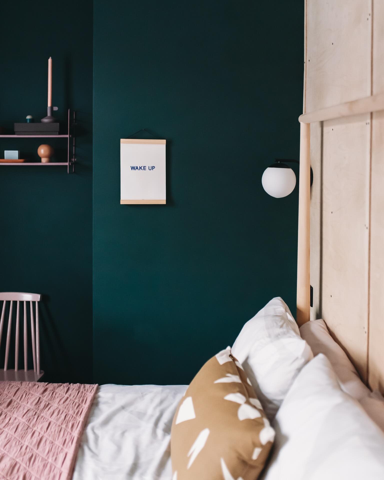 Dark green bedroom with plywood headboard & minimalist styling