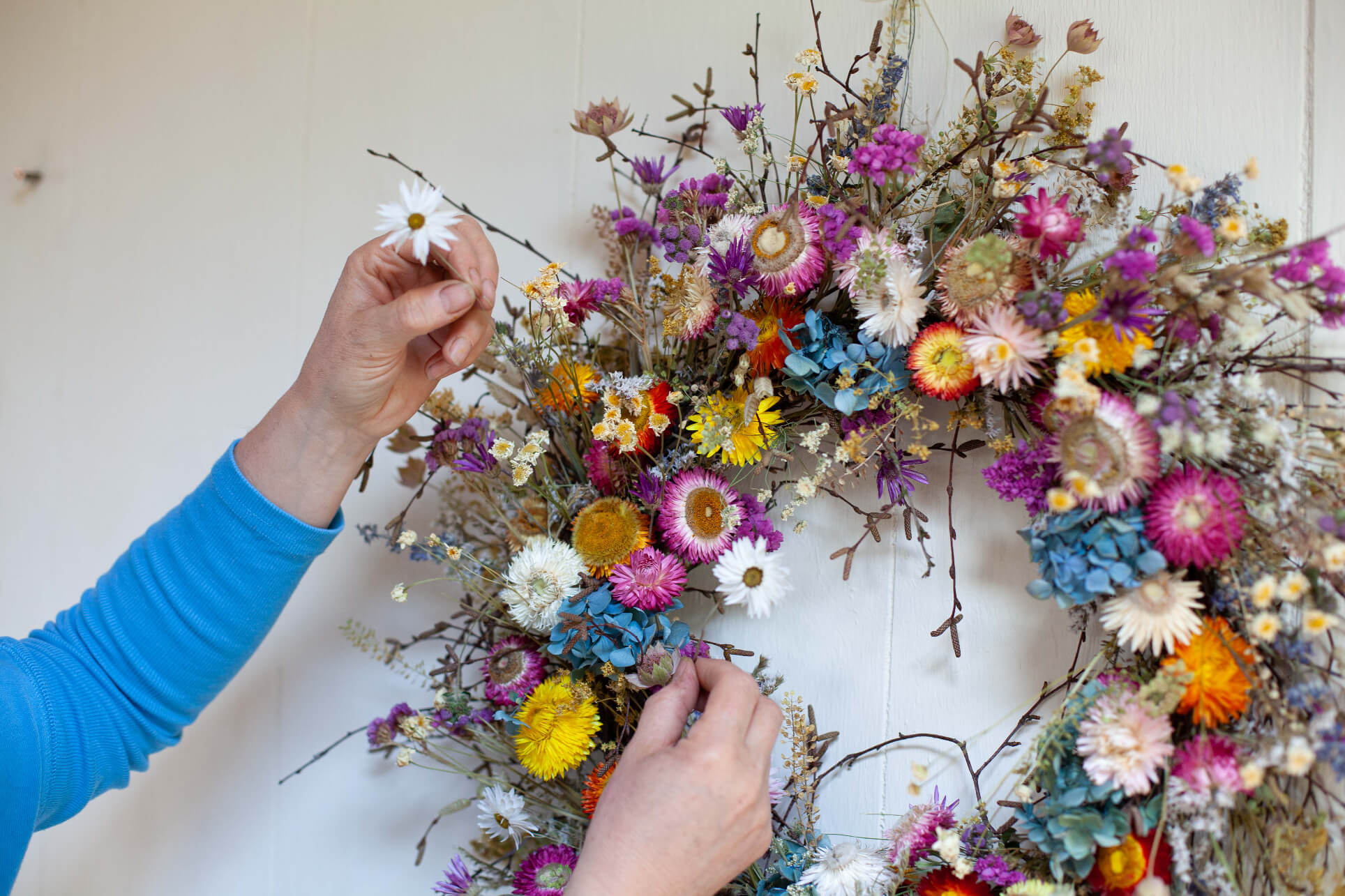 Sustainable interior everlasting floral sculpture designer Layla Robinson creating a dried flower wreath inside her Hay-on-Wye studio